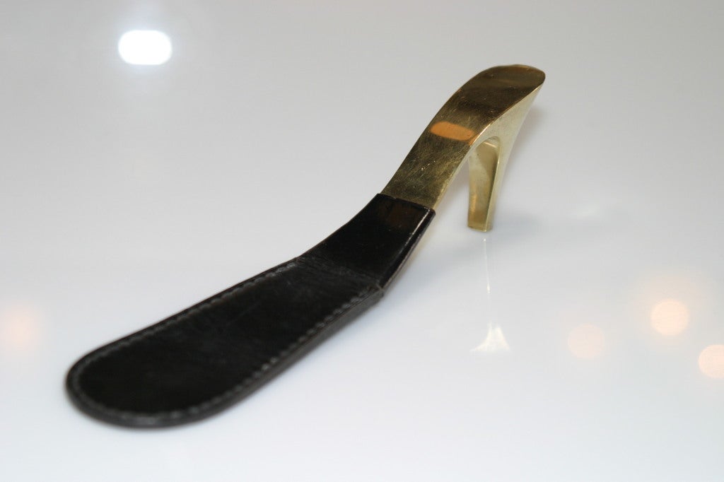This Mid-Century Modern shoehorn is cleverly fashioned in leather and brass by the masterful Viennese designer Carl Aubock (1900-1957). The object's shape is that of an elongated shoe with a brass heel that is meant to be used as a handle.
Auböck