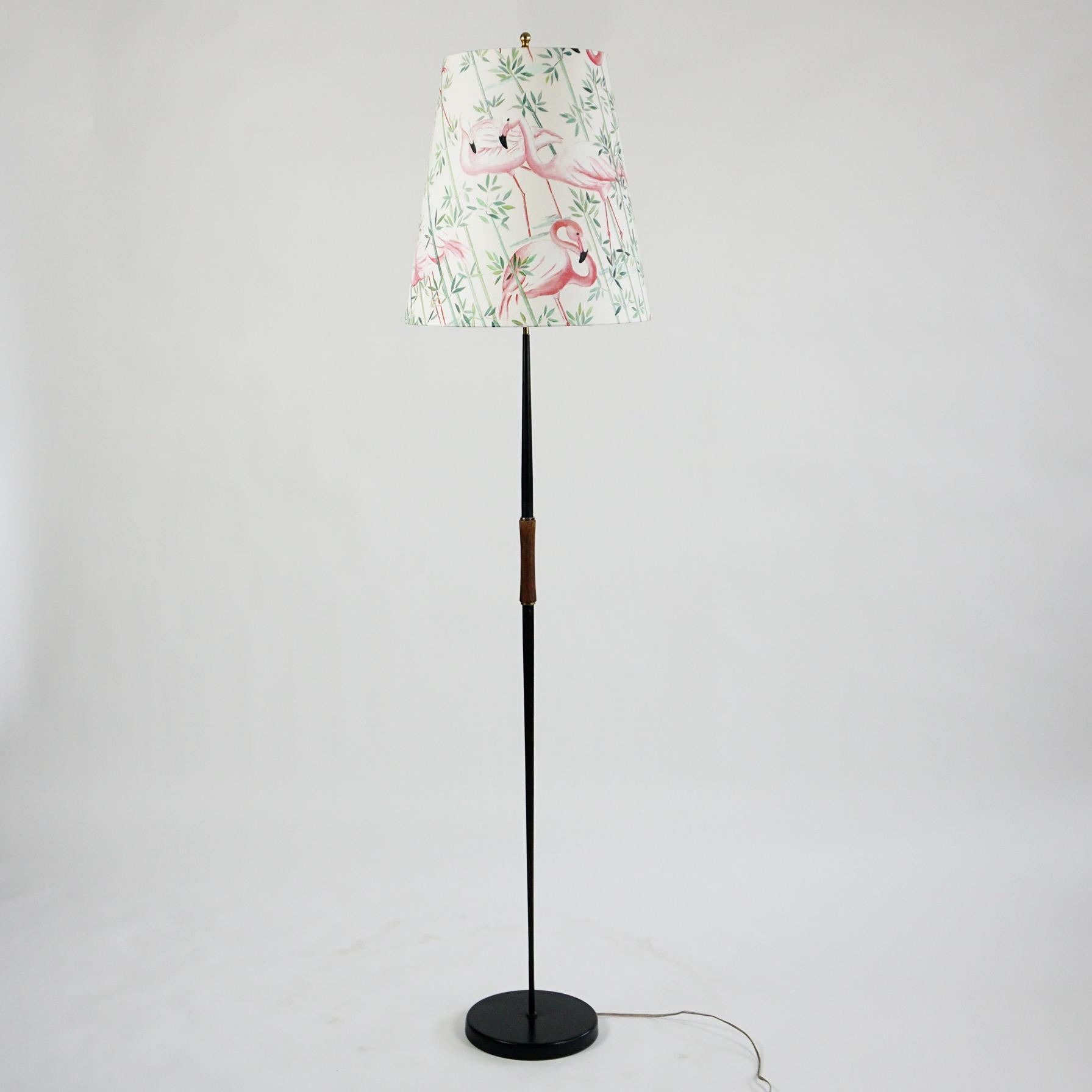 This charming Austrian midcentury floor lamp features a black lacquered iron base and a brass final fitting on the top which holds the shade, which has been renewed and its fabric shows pink Flamingo and green floral decor.
Its style is very close