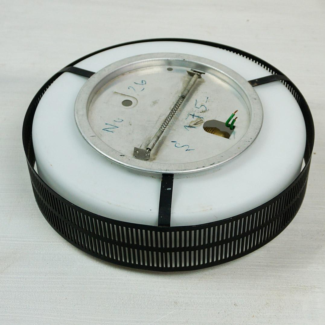 Cette applique ou plafonnier circulaire autrichien du milieu du siècle a été  produit en Autriche  dans les années 1960, probablement par Rupert Nikoll.
Il comporte un  base annulaire perforée laquée noire avec un abat-jour circulaire en verre