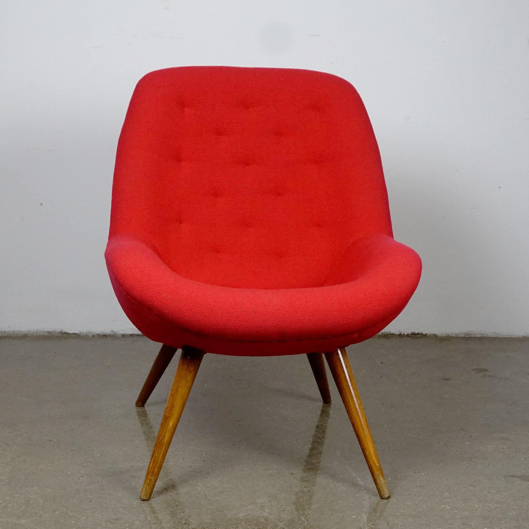This nice and charming club chair or bucket lounge chair with tapering walnut legs was designed and made in Austria in the midcentury. It´s shape reminds to the style of club chairs designed by Miroslav Navratil, but still with some differences.
We