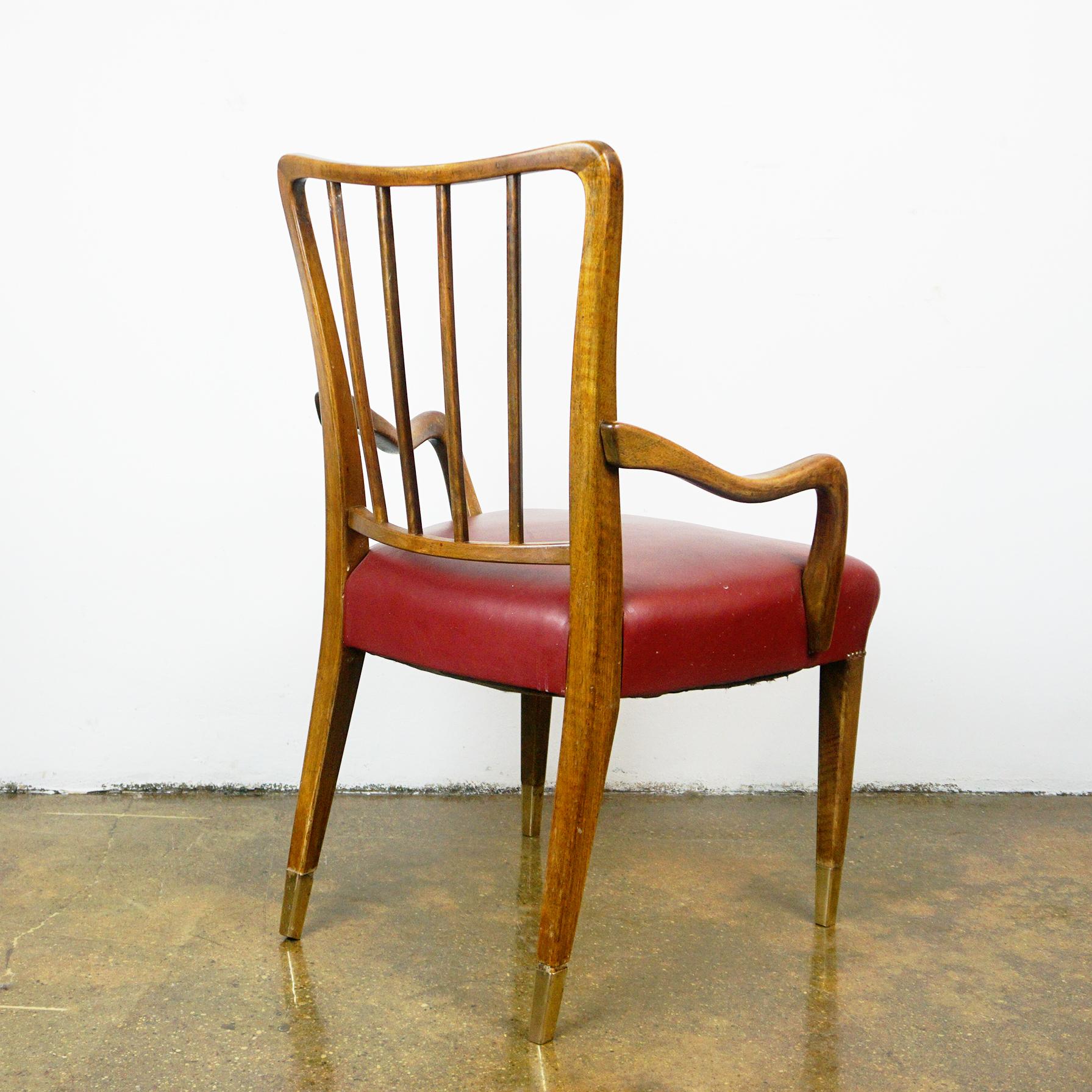 Cet ensemble élégant et confortable de huit fauteuils de salle à manger a été conçu par l'architecte et designer autrichien Oswald Haerdtl et fabriqué dans les années 1950 à Vienne. 
Les chaises sculptées sont en noyer et en laiton, avec des sièges