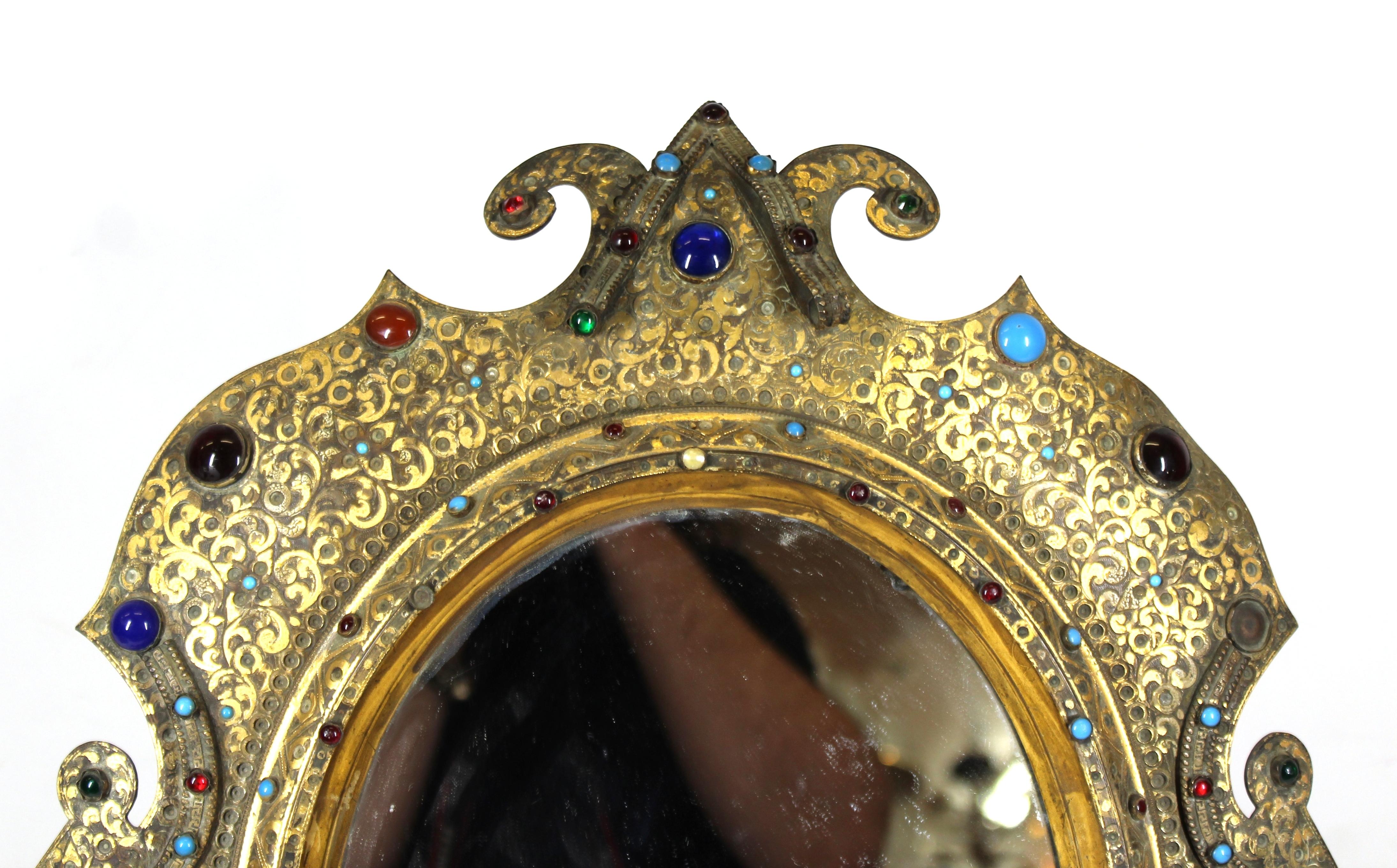 Austrian Moorish Revival period table mirror in gilded bronze, with enameled surface and jewel cabochon inserts. The oval shaped mirror stands on scrolled legs. Minor losses to enamel. Handmade in Austria during the mid-19th century, the piece has a