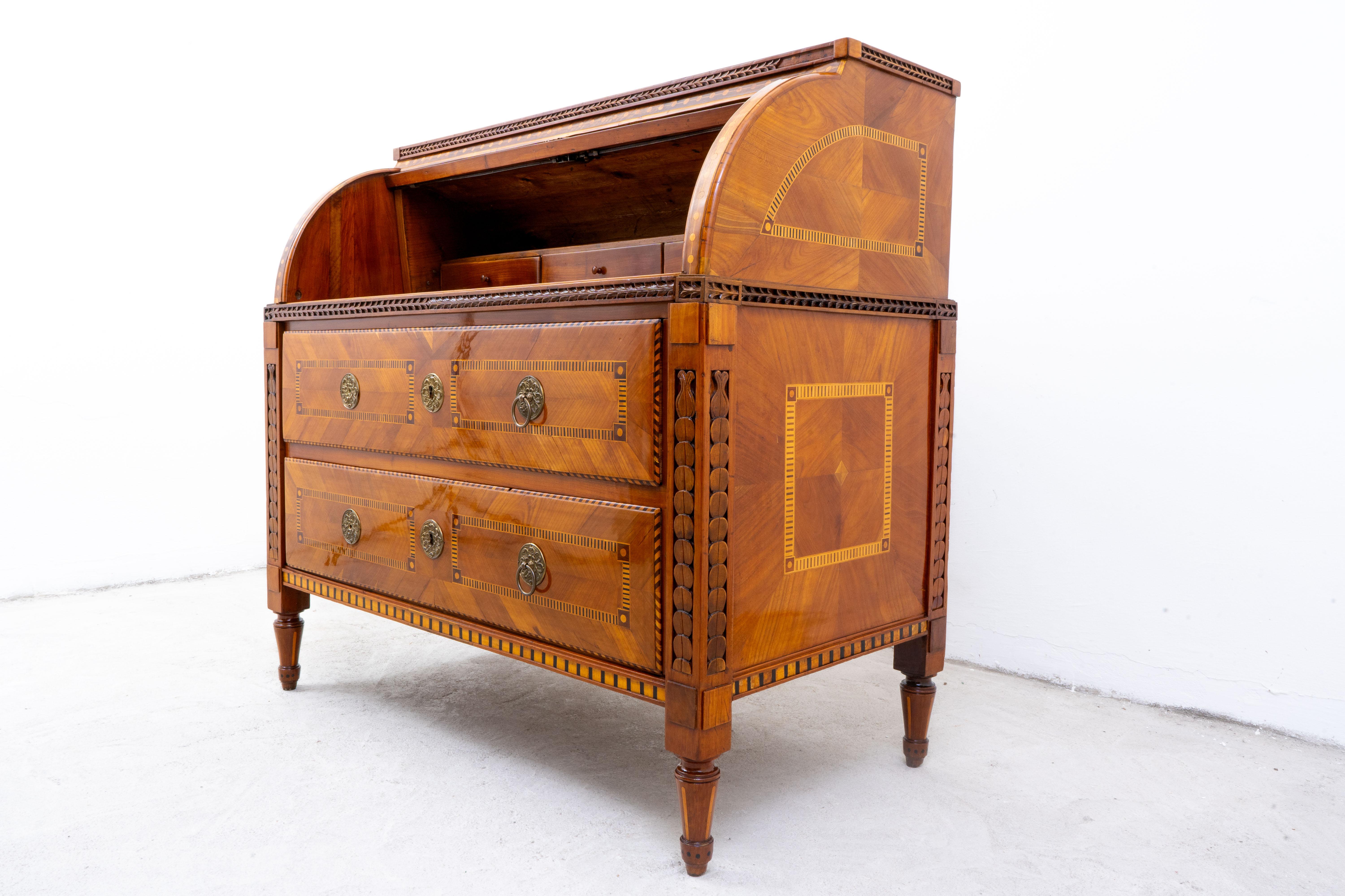 This elegant Austrian cylinder roll-top desk, dating from around 1780, is a refined example of late Neoclassical (copf style) craftsmanship. The piece is constructed from a fine combination of cherry, pine, and walnut, richly enhanced with veneered