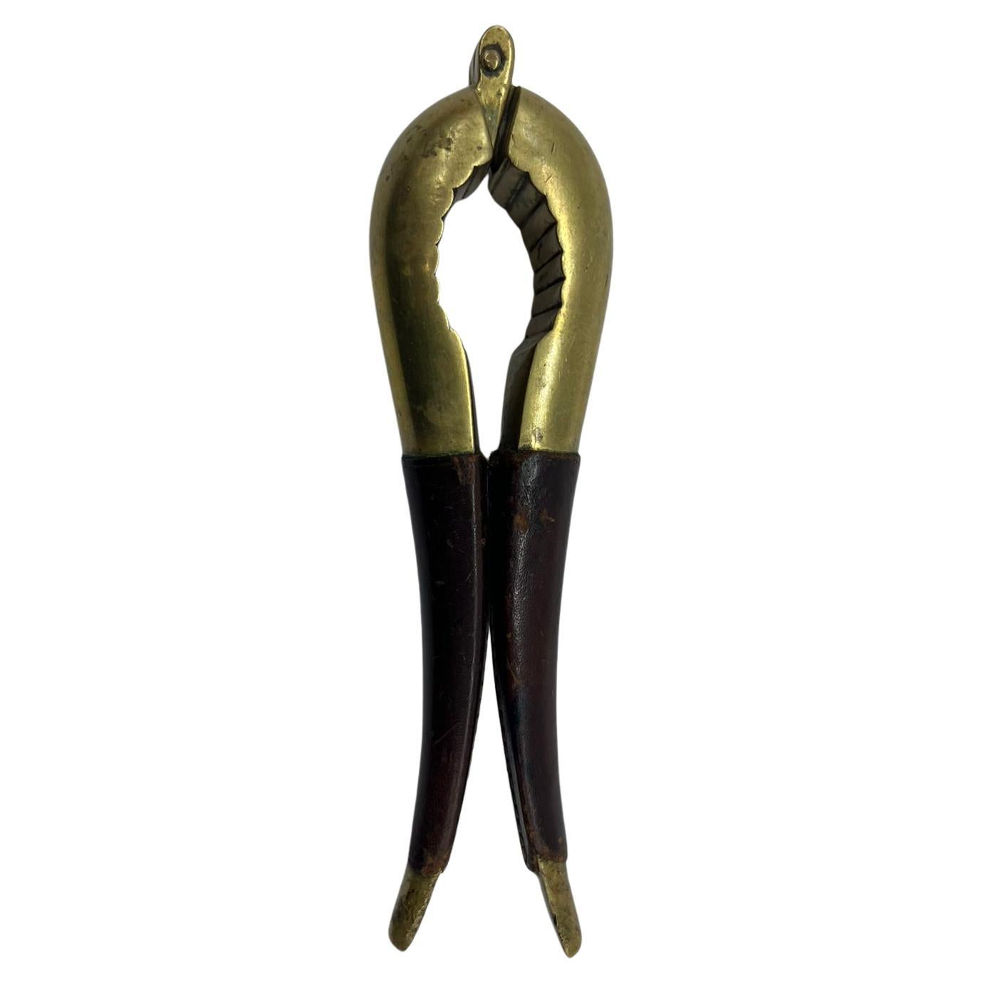 A beautiful and elegant nutcracker made and signed by Carl Auböck in Austria around 1950s. The nutcracker is made of brass and leather.