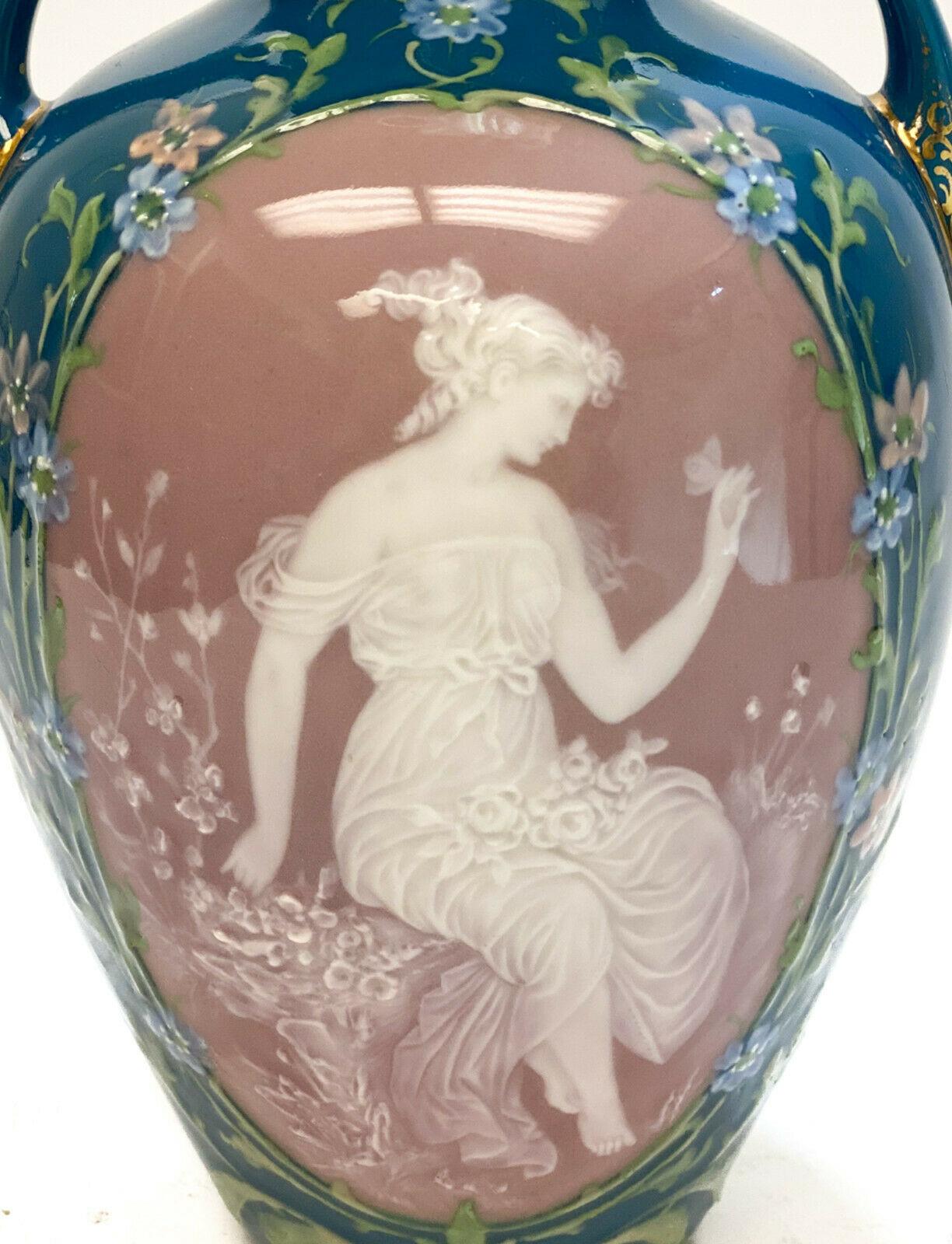 Austrian pate-sur-pate porcelain twin handled vase. A fine quality pate-sur-pate figural beauty in delicate garbs. A teal blue ground with the middle in white slip and multicolored slip decorations to the edges. Austrian pate-sur-pate mark to the