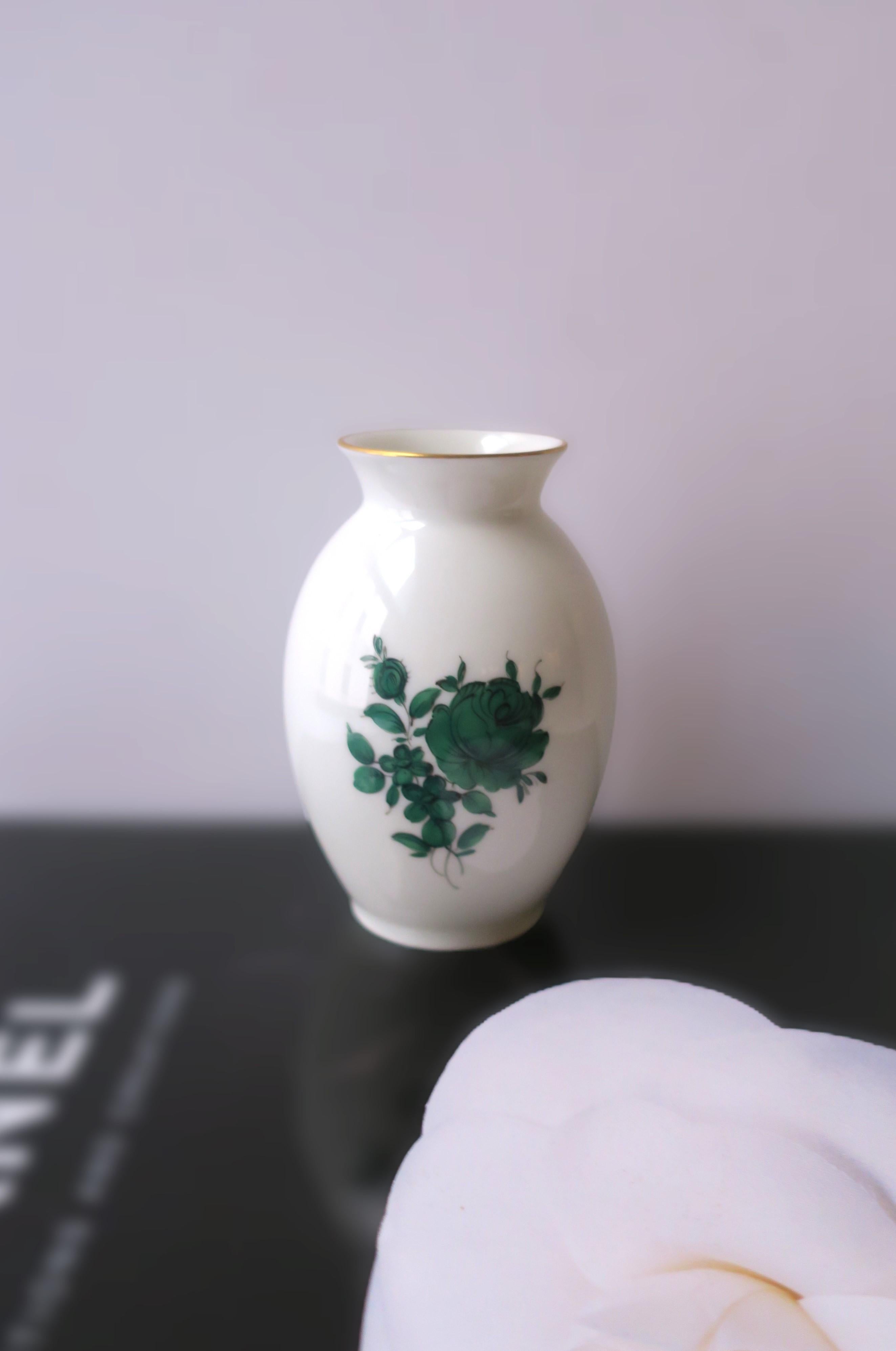 A small Austrian white porcelain vase with large emerald green rose flower at center, by Augarten Porzellanmanufaktur, circa late-20th century, Vienna, Austria. The perfect accent vase with center rose flower accompanied by smaller flowers and
