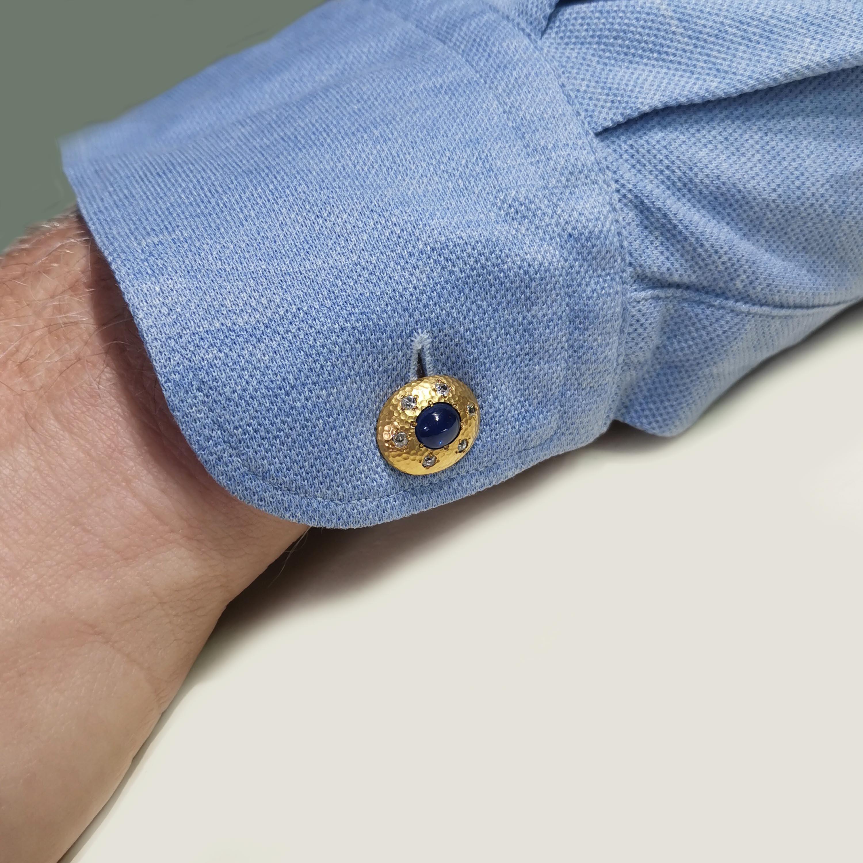 Ein Paar österreichische Saphir-, Diamant- und Goldmanschettenknöpfe, besetzt mit hochgewölbten Cabochon-Saphiren, umgeben von Diamanten im Altschliff, auf gehämmerten, niedrigen ovalen Goldkuppeln, montiert in 18-karätigem Gold, mit Barbeschlägen,