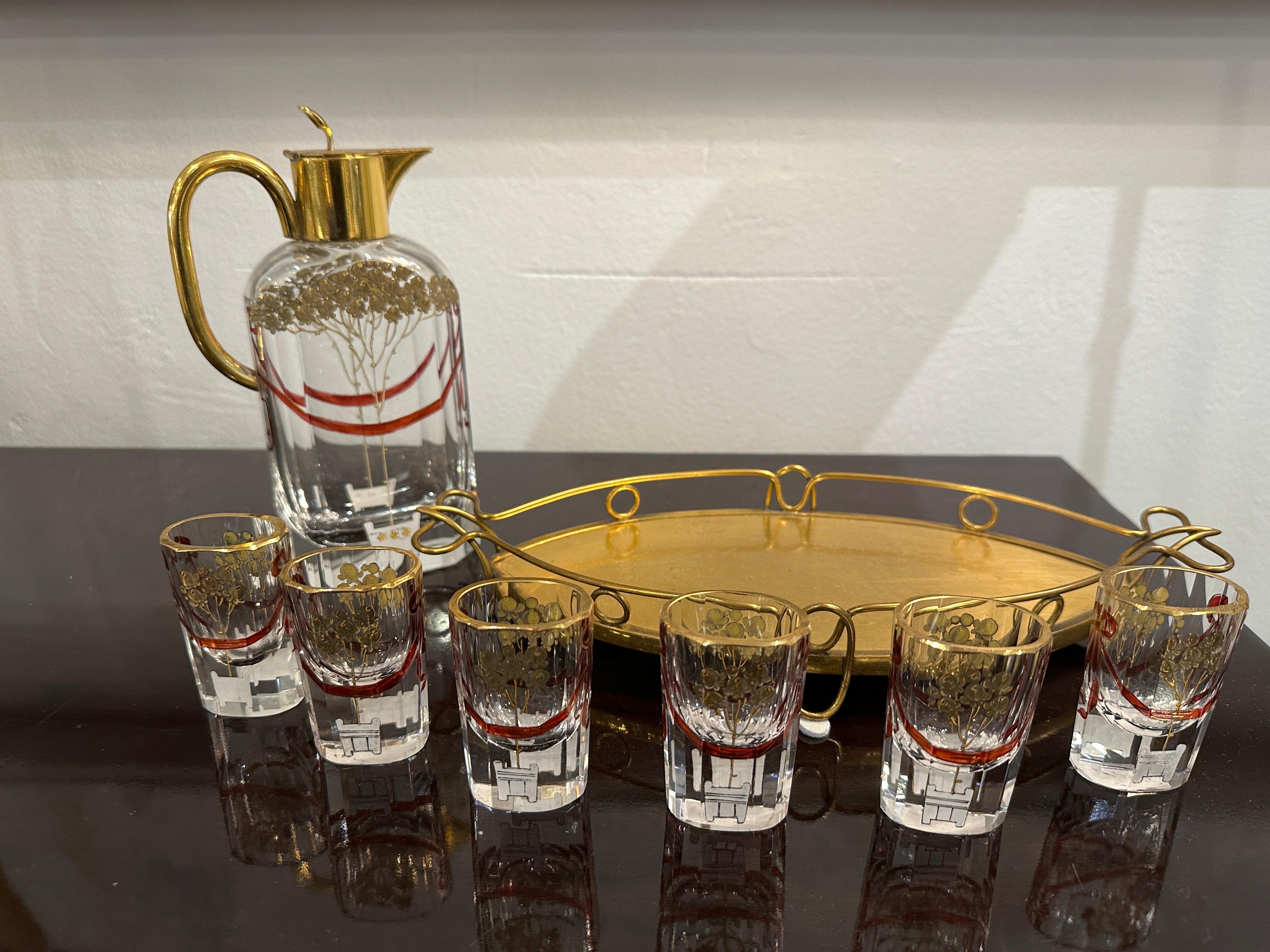 This set of 8 pieces include: decanter, 6 cordial glasses and the tray. Beautifully hand painted on geometric faceted crystal glassware, the designs feature red ribbons and gold florals topiaries. Amazing period set in nearly un-used condition. Each