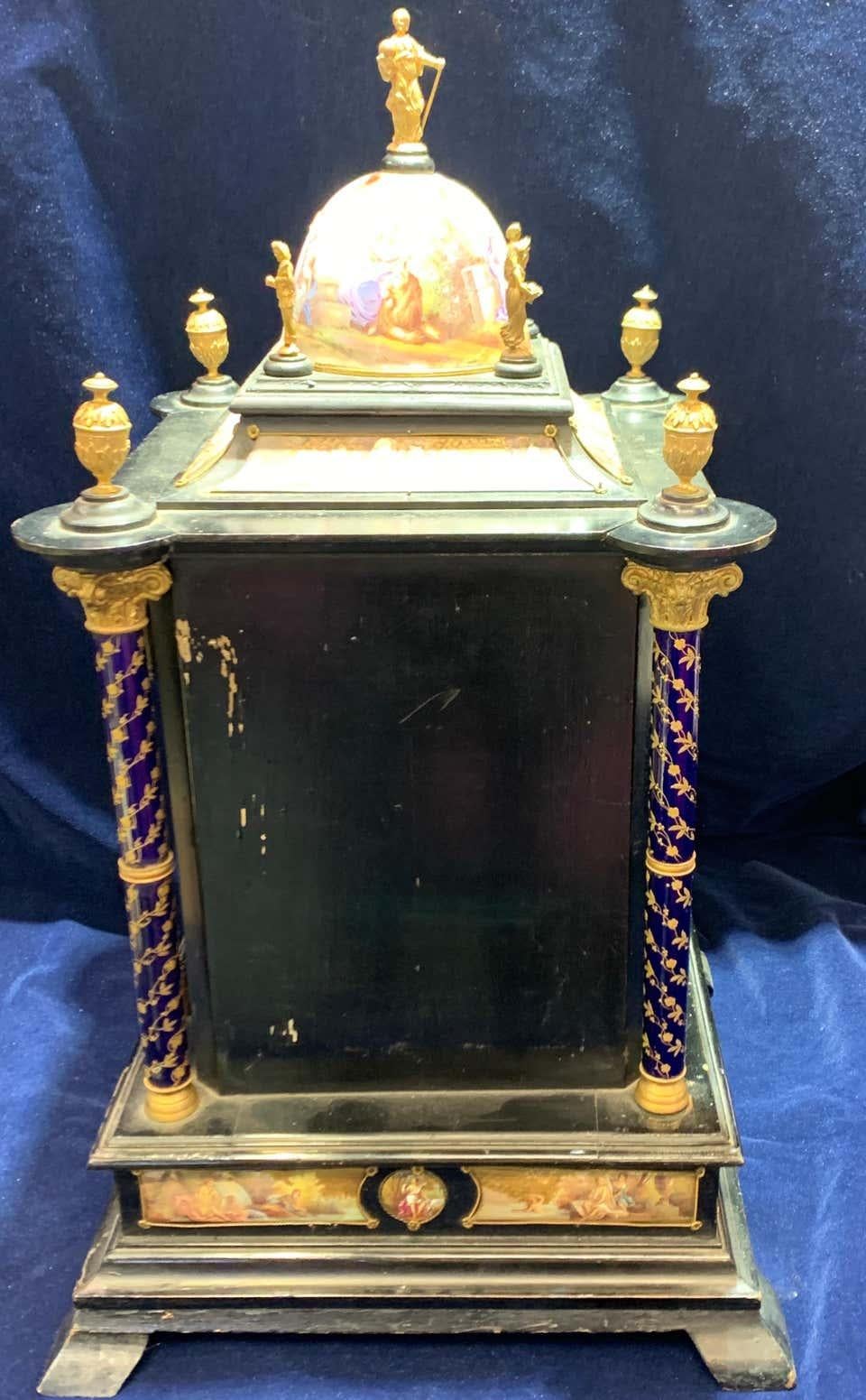 Austrian silver-gilt, wood & enamel clock cabinet table

Classical figures painted on a gilt diaper bottom. An enamel clock face, matching the corners. Columns made of Corinthian with painted florals with urns on top. Includes an opening back door