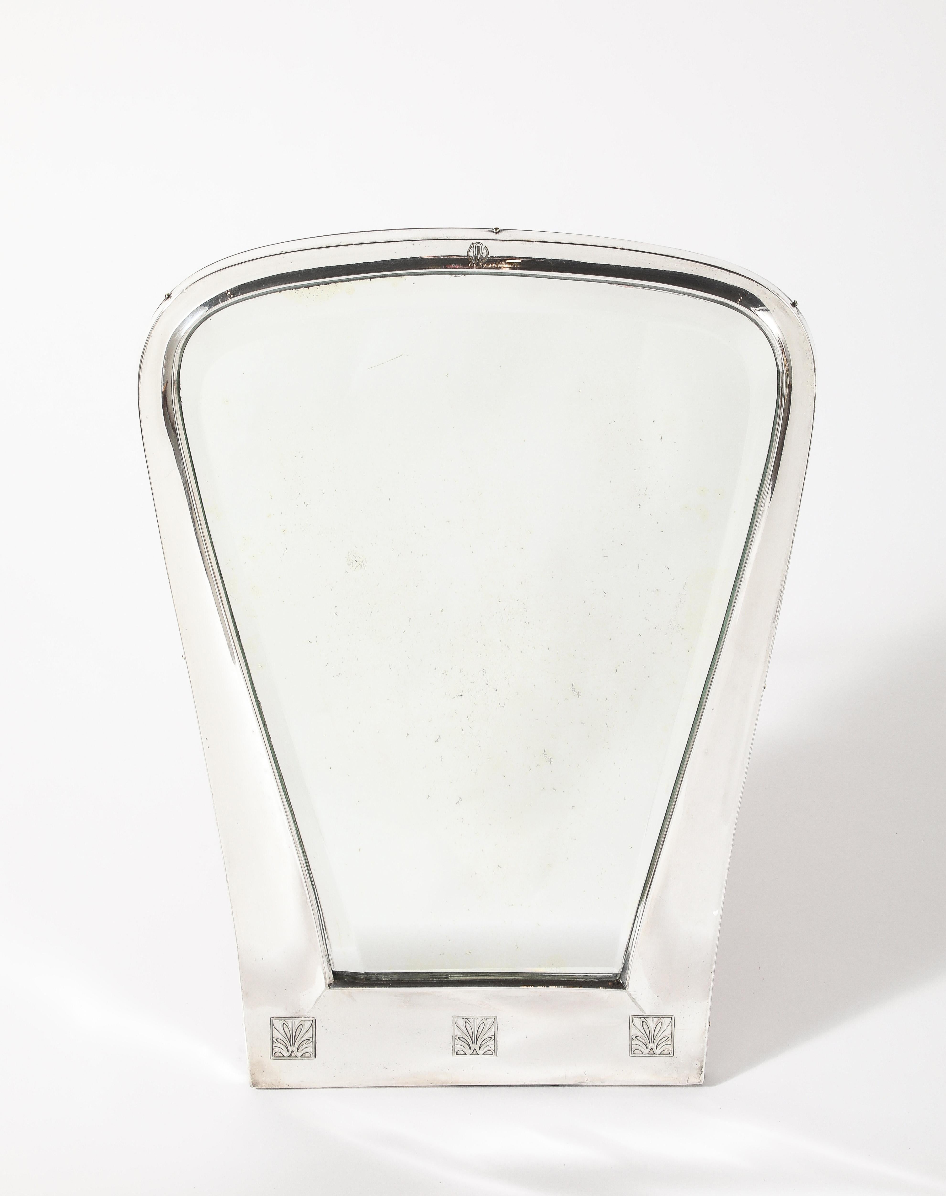 Austrian Silver Toilette Mirror, highly unique with a very elegant shape of the early Art Deco era.  With three floral engravings decorating the base, the crest with the engraved initials RW / WR.  With original beveled glass and mahogany wood back