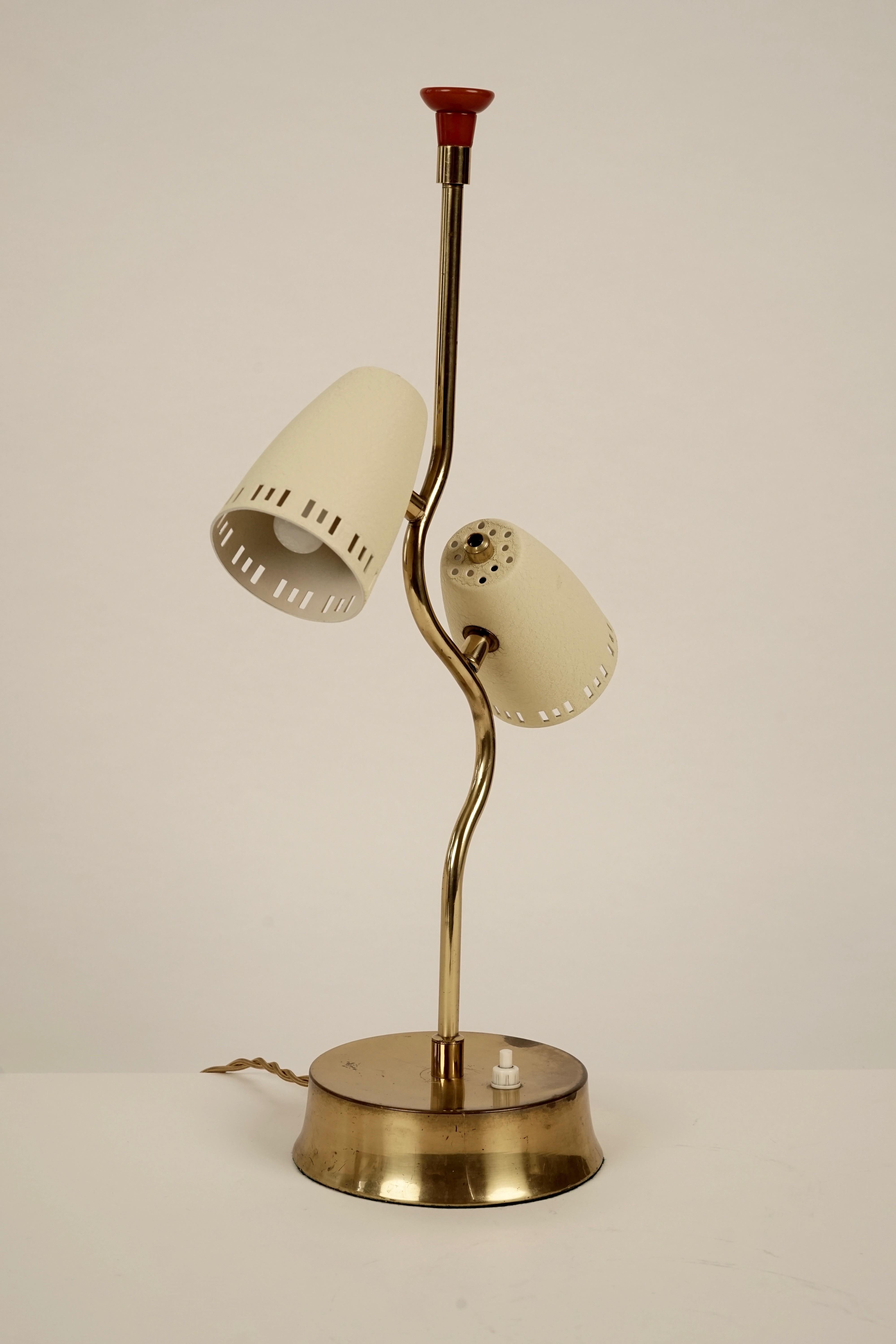 This delicate, humorful table lamp from Austria dates circa 1950s. Made of brass with off white colored shades and a bakelite grip in red.
It comes with a cloth covered cable. The shades do not rotate. To change position you turn the lamp, while