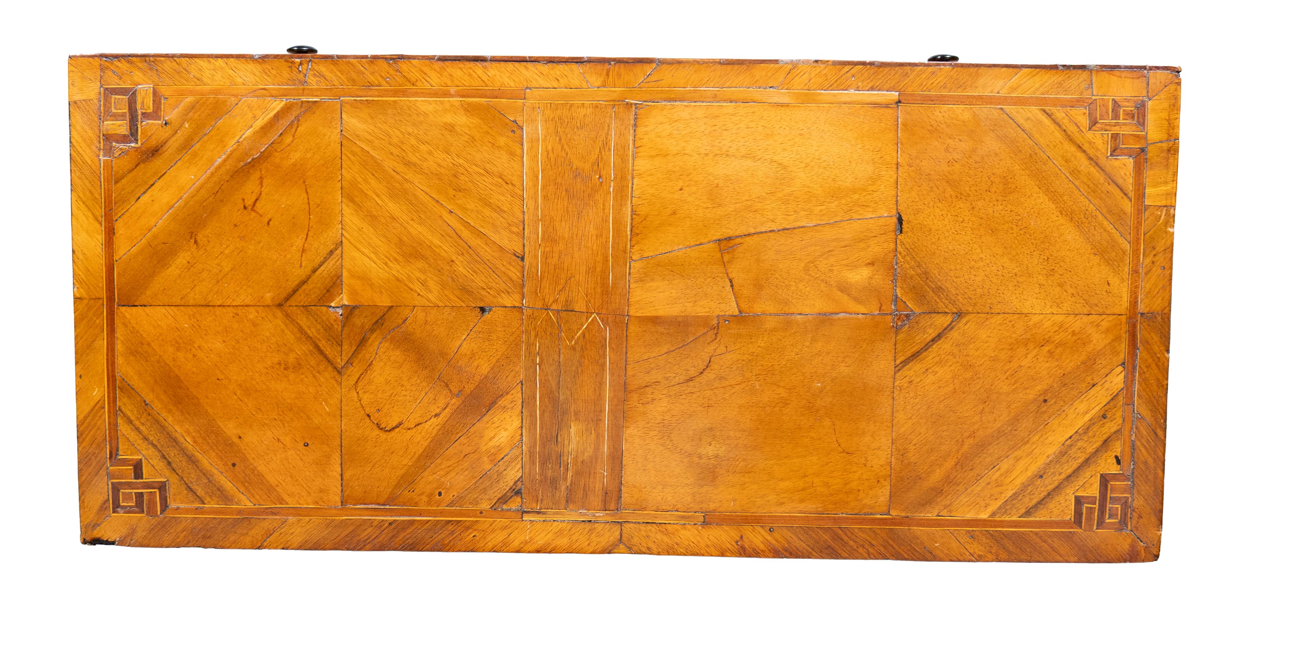 Dessus rectangulaire sur trois tiroirs avec boutons et écusson en bois. Pieds de chignon.