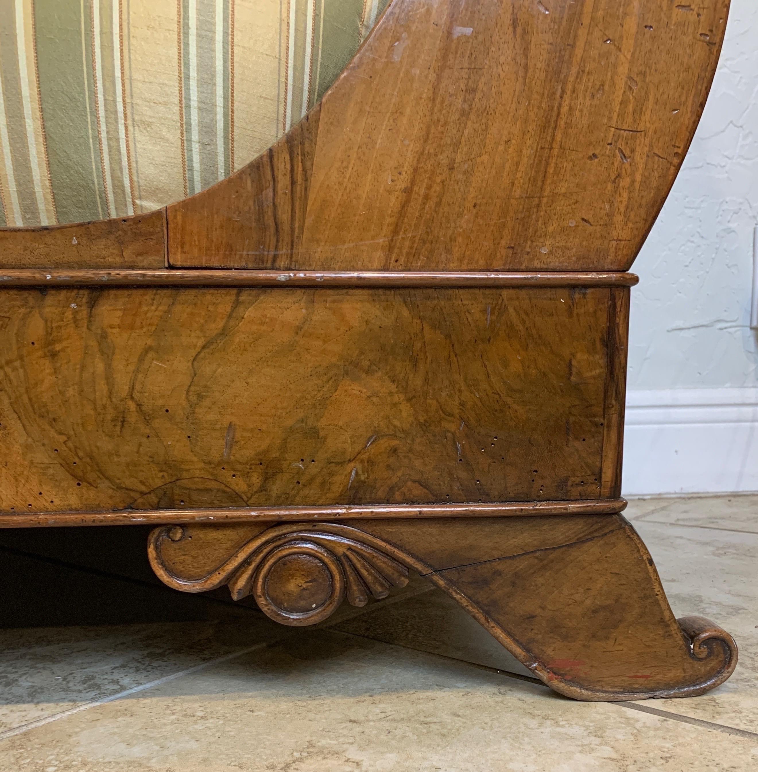 Biedermeier sofa made of walnut. Terminating in carved scroll feet. Each side with a rolled arm. Structurally sound.