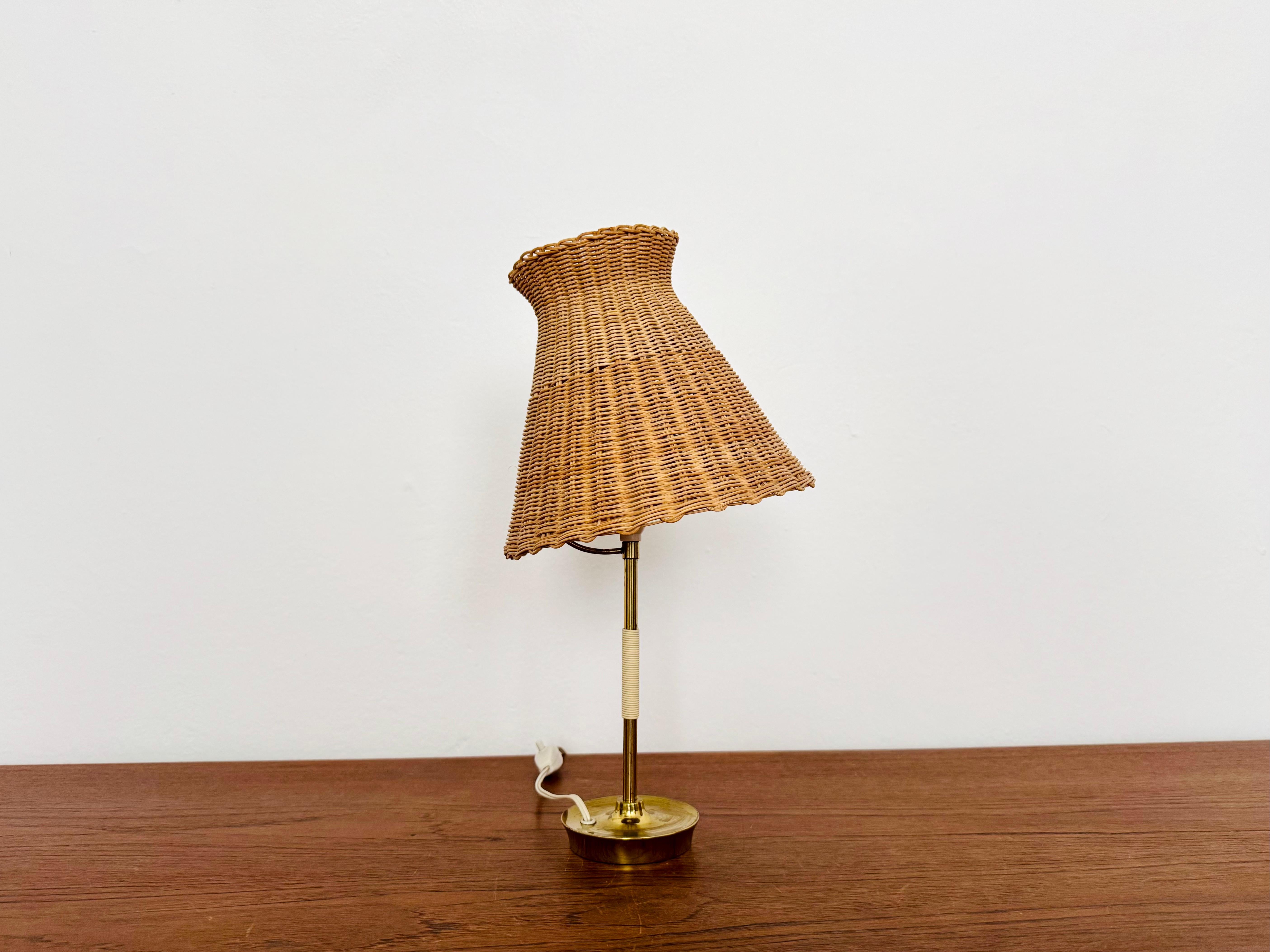 Wonderful table lamp from the 1950s.
Great and unusual design with a fantastically elegant appearance.
The rattan lampshade creates a very cozy atmosphere and a spectacular play of light.
Very rare collector's item with original lampshade.

Design: