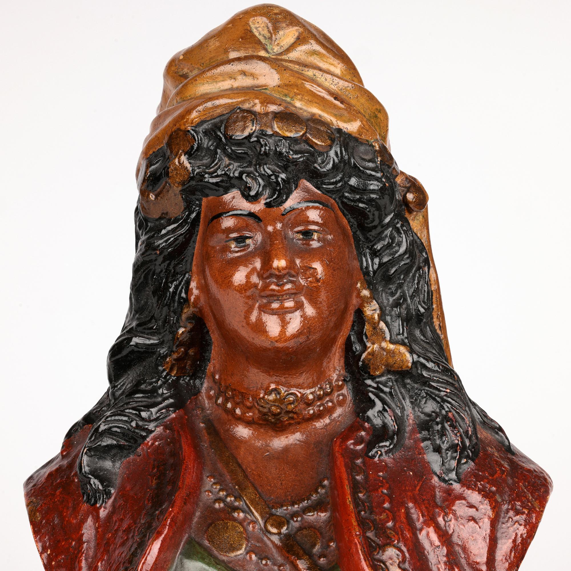 Un élégant buste antique en terre cuite austro-bohémienne d'une gitane datant d'environ 1890. Le buste à la taille repose sur une base ronde à piédestal intégral et représente une femme portant un gilet sur une robe et un sac, probablement destiné à