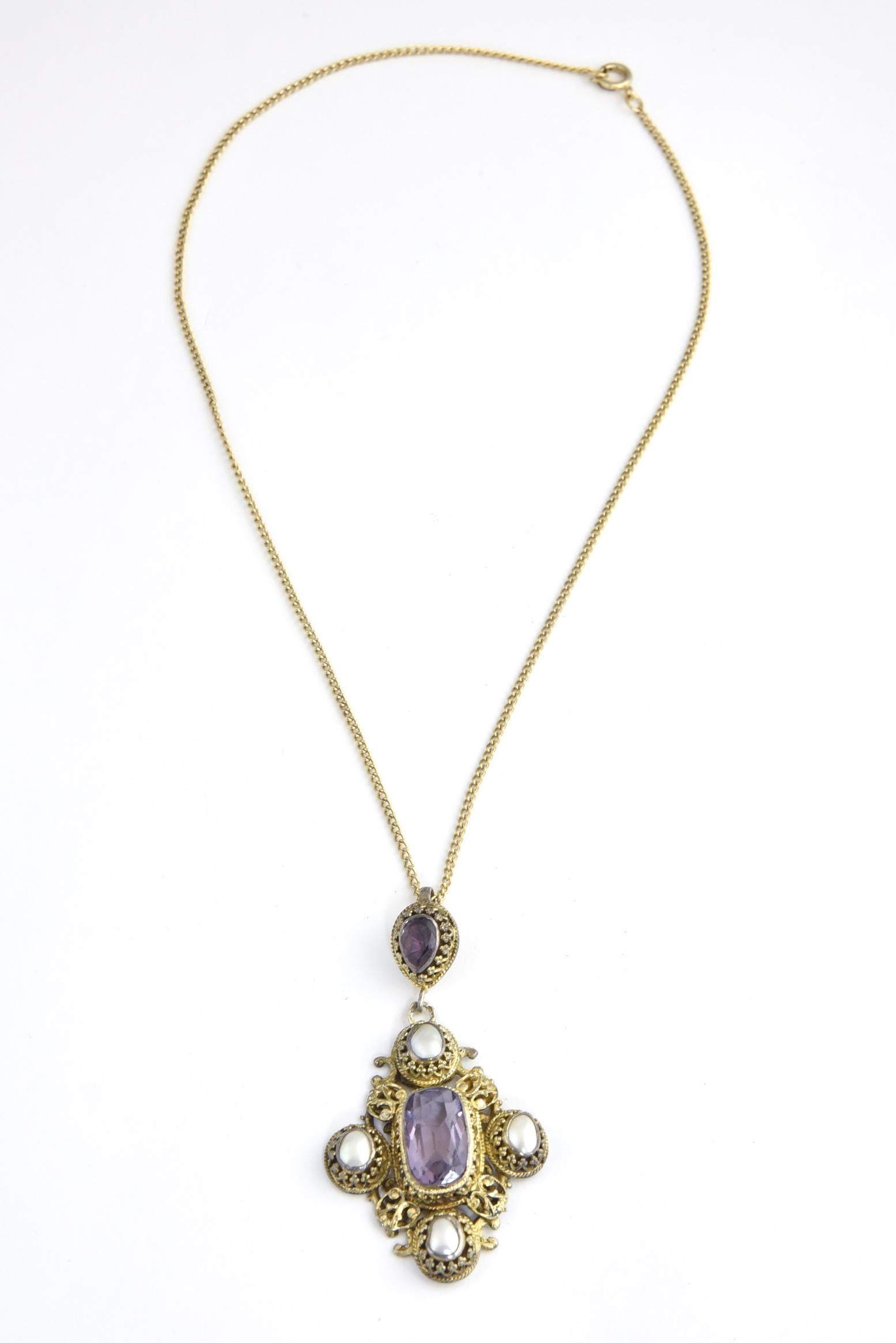 Austro-Hungarian amethyst necklace. Created between 1860 and 1910 in workshops in Austria-Hungary, this pendant necklace features a rectangular amethyst hanging from a pear garnet drop. Central amethyst stone is surrounded by ornate gilt silver