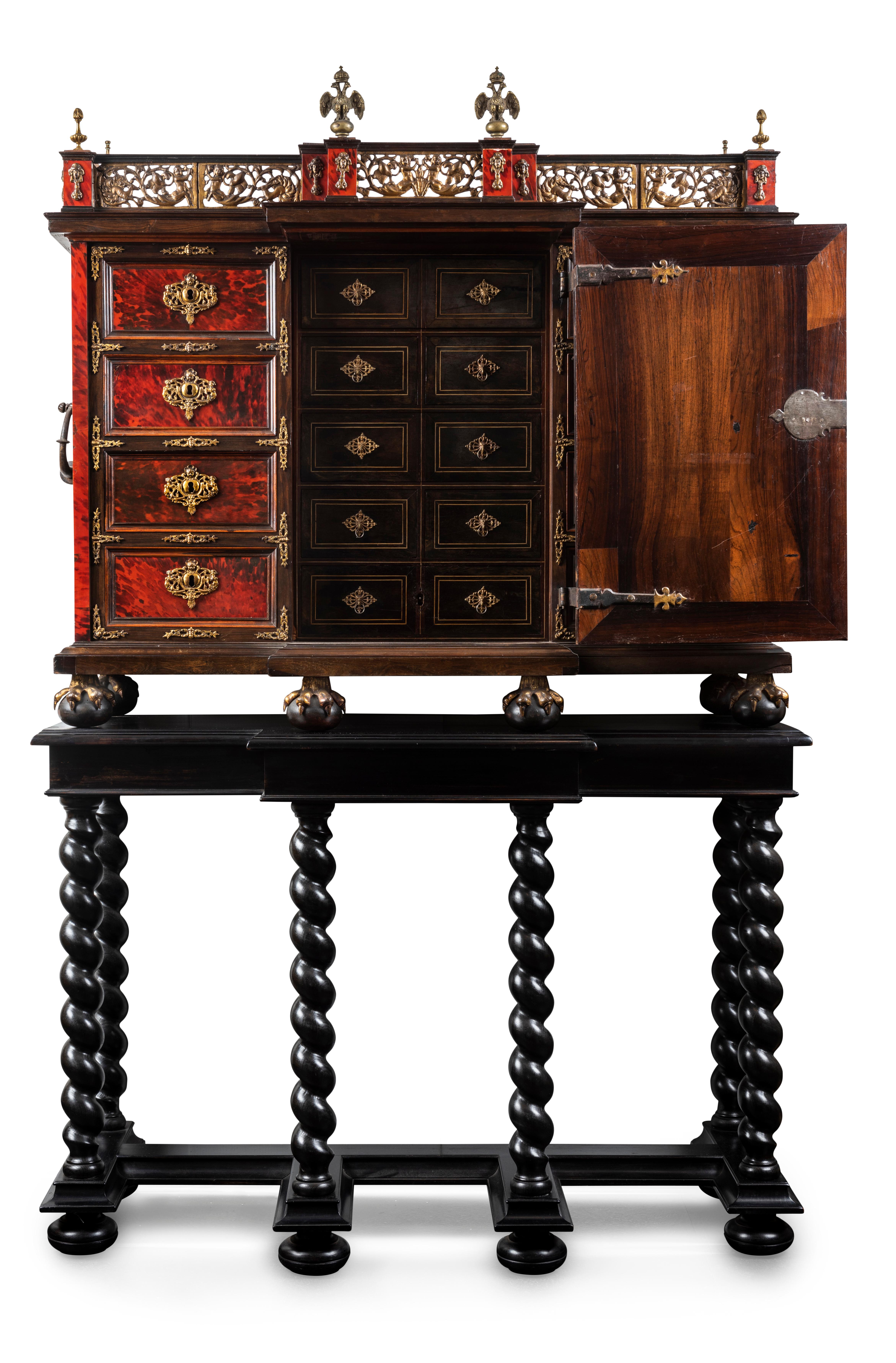 The cabinet of rectangular form with a break front palisander body enlivened with re tortoiseshell and separated into three sections, the central section with the double pilasters each ornamented with pendant gilt grass grotesques framing a putto