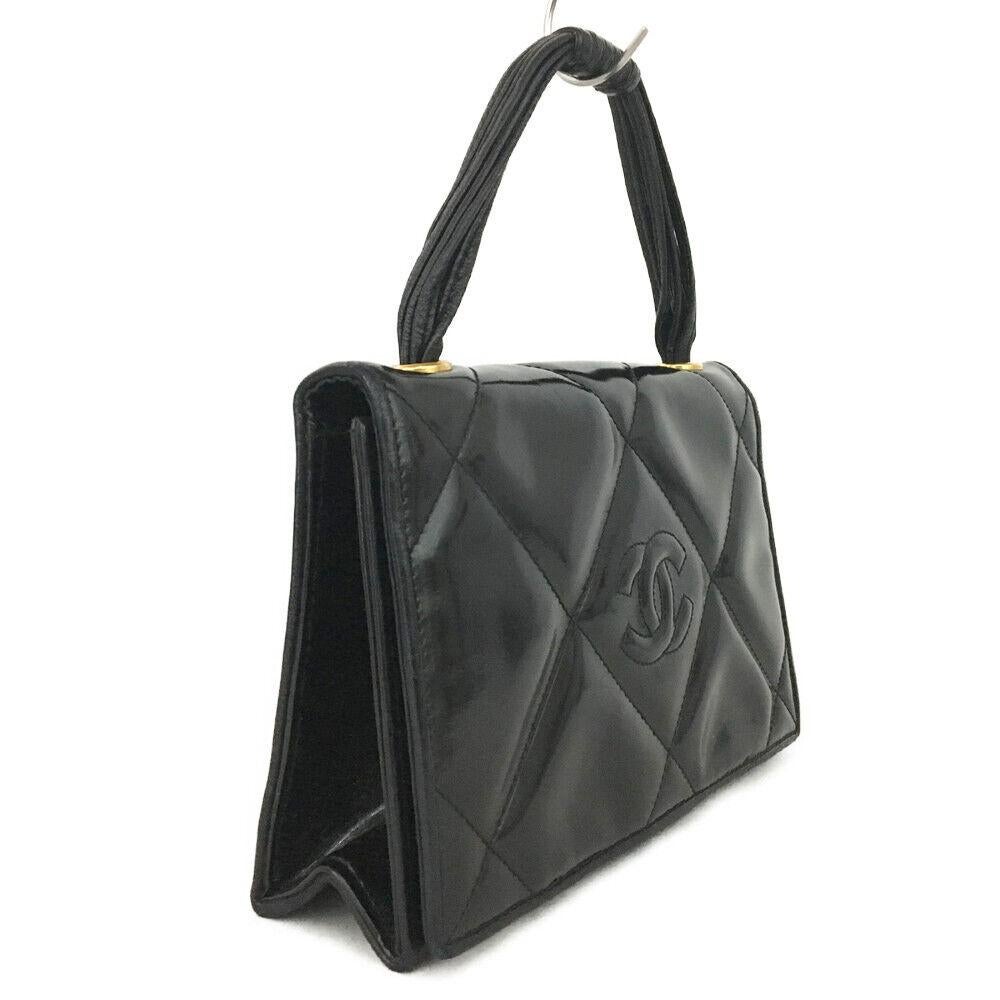 Black Top handle Chanel quilted hand bag. This hand bag has a wonderful classic quilted/ knit design. the knit goes thorough the entire upper body of the bag and extending around the top flap. The leather body and the leather handle are made from
