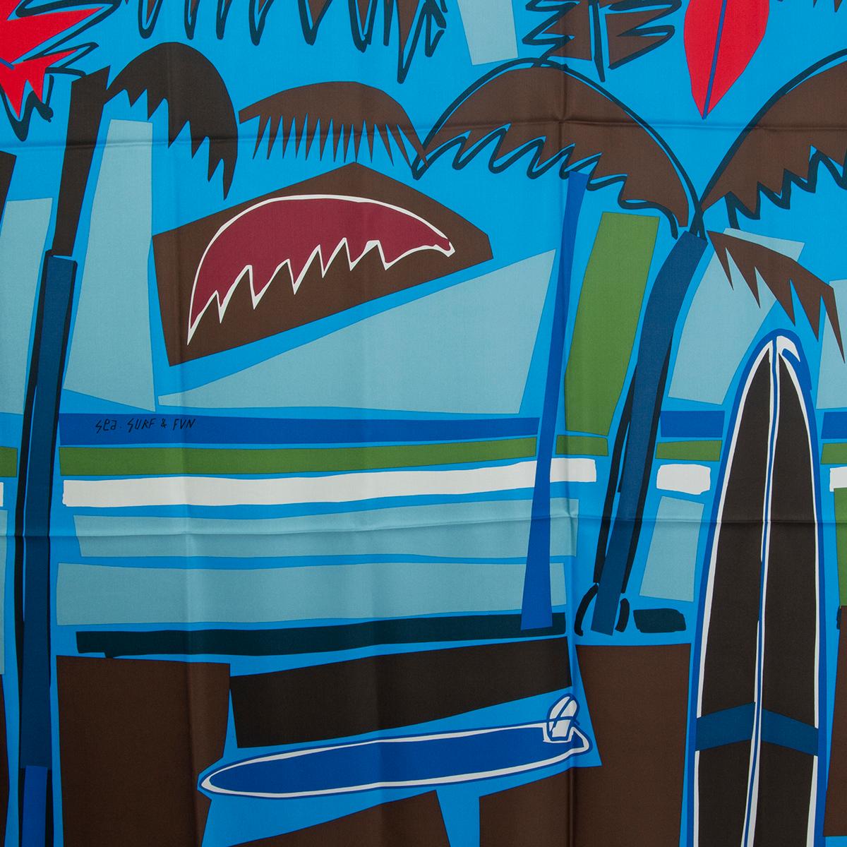 Hermès 'Sea Surf & Fun 140' scarf by Filipe Jardim in blue silk twill (100%) with red hem and details in espresso brown, brown, navy, burgundy, oilve green, baby blue and black. Has been worn and is in excellent condition. 

Width 140cm