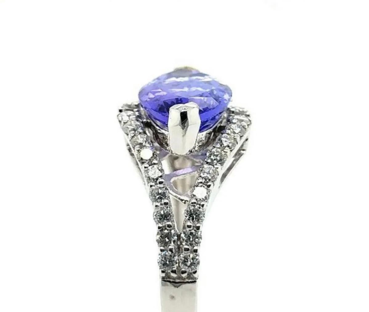 Stunning 18k white gold tanzanite and diamond ring. Size 7, weighing 28.1g, this ring is certified and appraised for $8530 (certification/appraisal included). The East-West set 2.42 carat marquise-cut tanzanite is prong set between .39 carats of