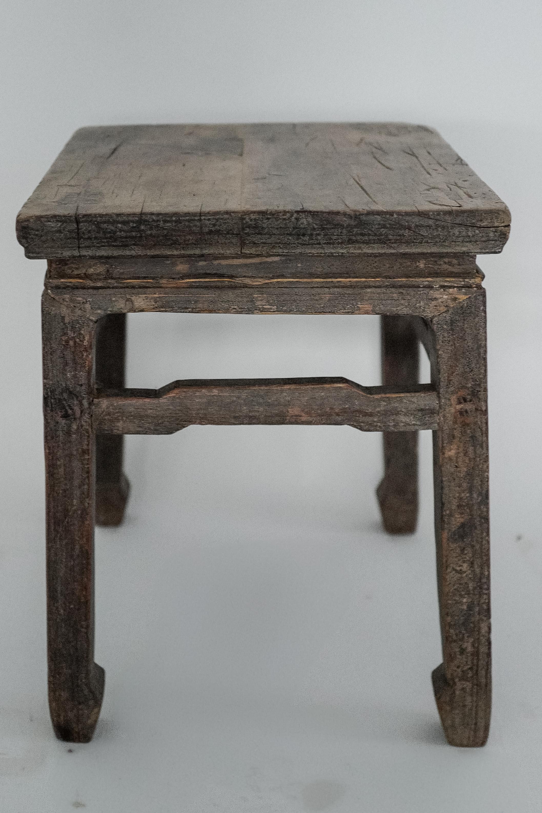 Cette table d'appoint chinoise du XIXe siècle, magnifiquement vieillie et fabriquée en noyer massif, incarne le travail du bois traditionnel chinois et le charme rustique. Avec son plateau carré et ses pieds robustes, cette table présente une riche