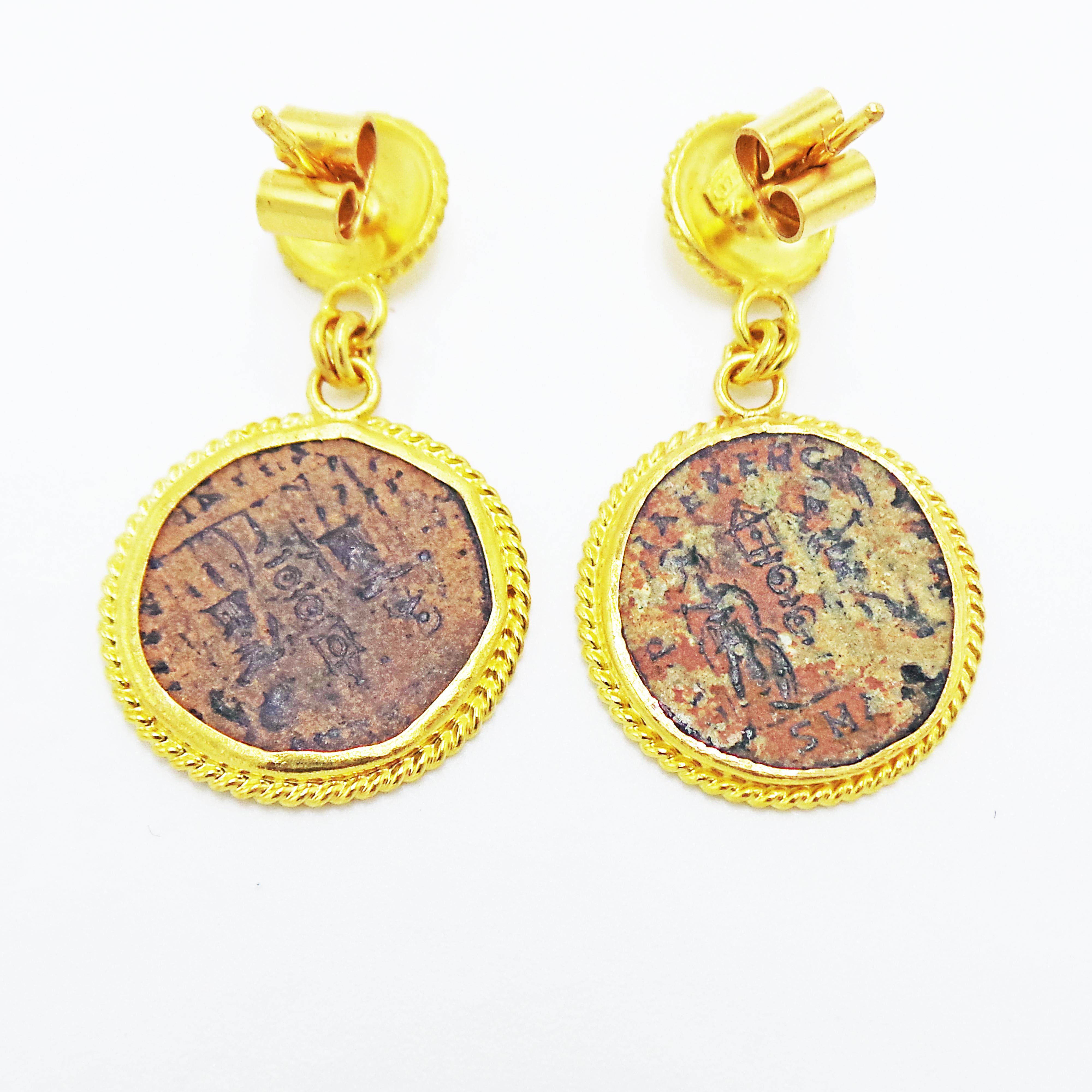 D'authentiques pièces de monnaie romaines en bronze (Constantius II, 337-361 ADS) sont serties dans des boucles d'oreilles pendantes en or jaune 22k.