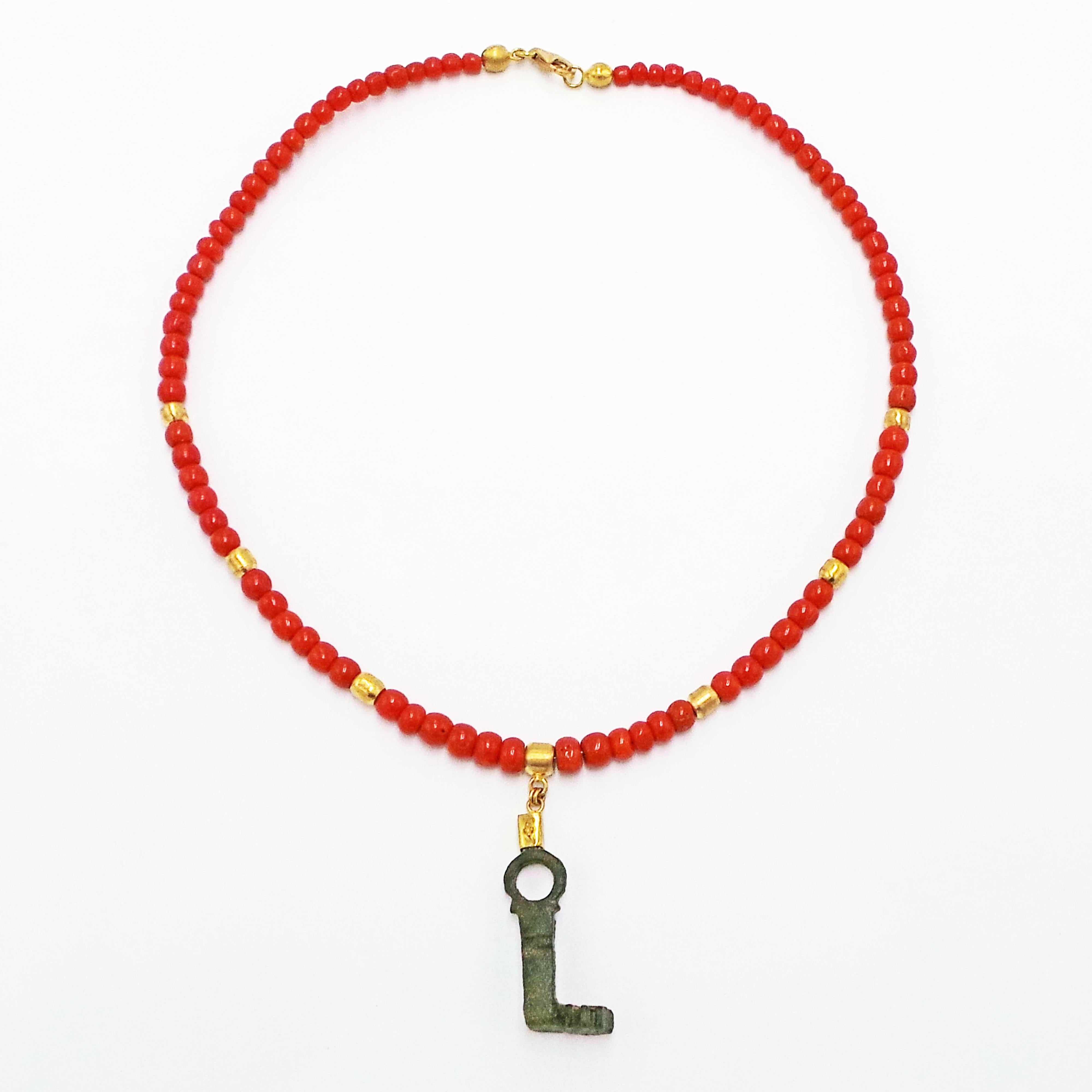 Ancient Roman bronze key (3rd-4th century AD) and 22k yellow gold pendant on a coral and 18k yellow gold beaded necklace.  Necklace is 17 inches in length and finished with an 18k gold lobster clasp. One-of-a-kind pendant necklace has a rich color
