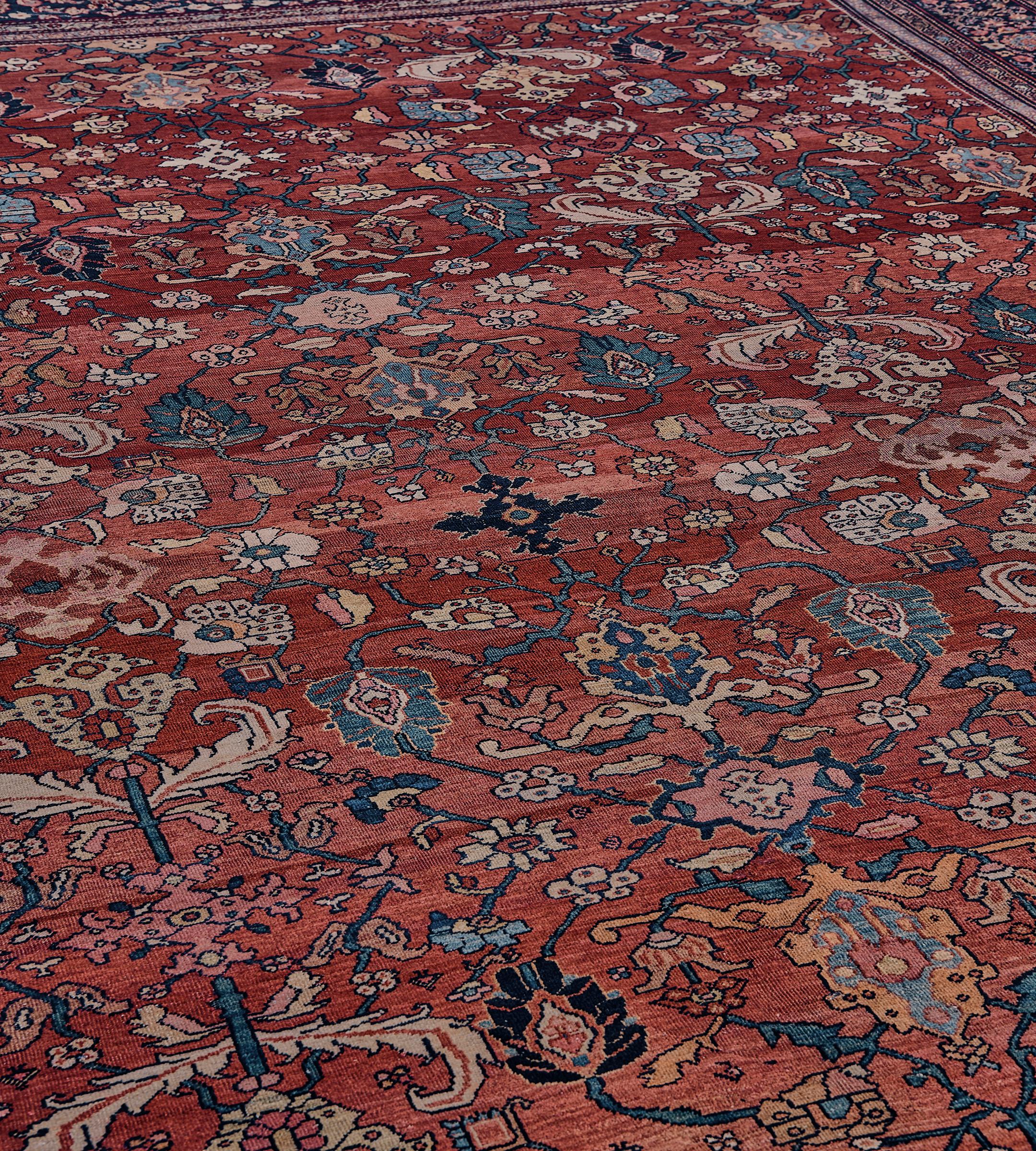 This traditional hand-woven Persian Fereghan rug has a shaded rust field of polychrome palmetttes issuing lozenge vine forming lattice and fine floral motif, in an indigo border of strung rosette pendants issuing dense floral motif, between a