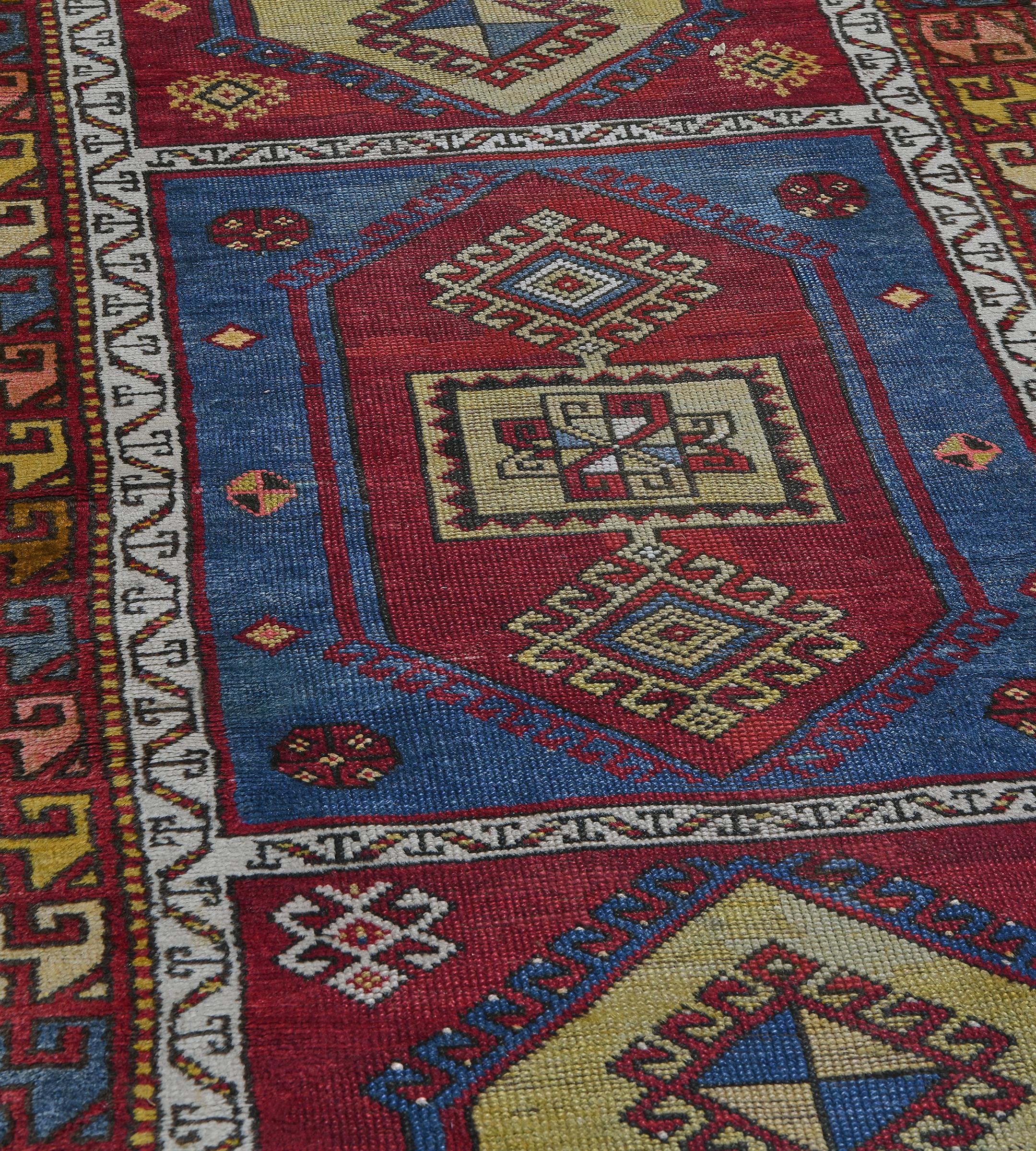 Cet ancien chemin de table turc présente un champ composé de sept panneaux rouge brique et bleu ciel contenant chacun un losange central crocheté polychrome avec un panneau central et un losange mineur crocheté à chaque extrémité, entouré d'autres