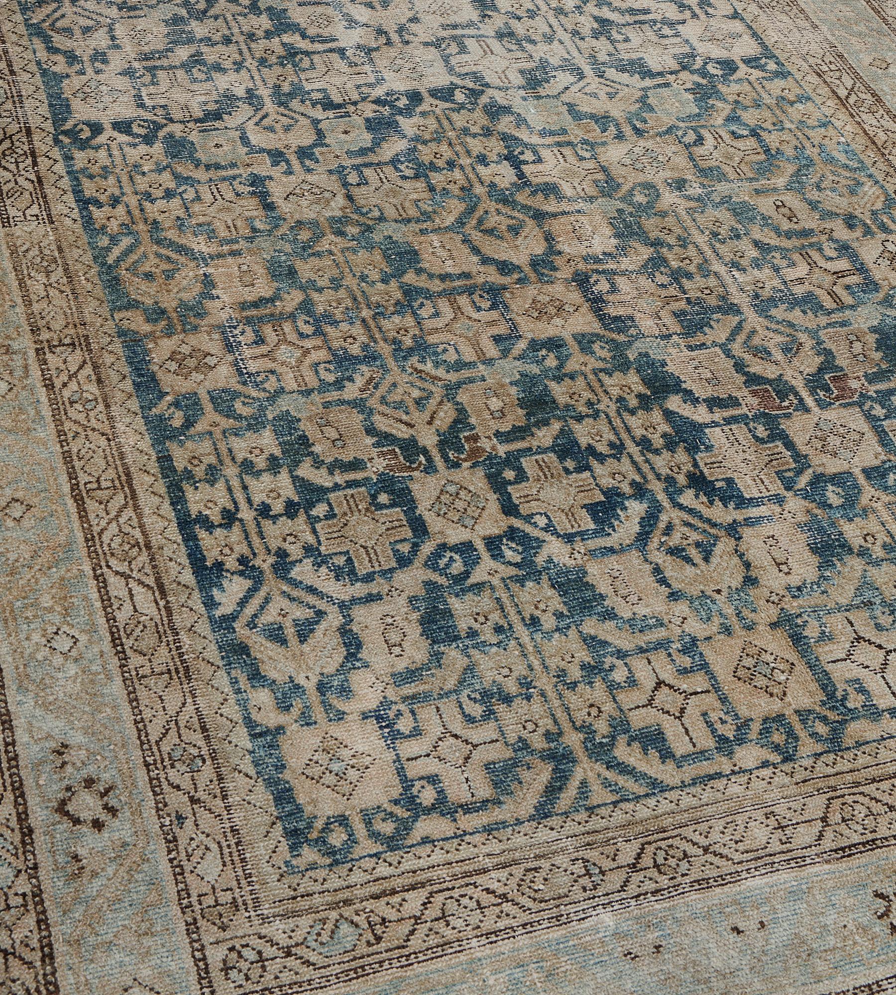 This antique Malayer rug has a shaded sea-blue field with an overall design of ivory, shaded brown and buff-brown angular panels linked by floral panels, serrated leaves and flowerheads, in a light blue border of buff-brown and charcoal-brown