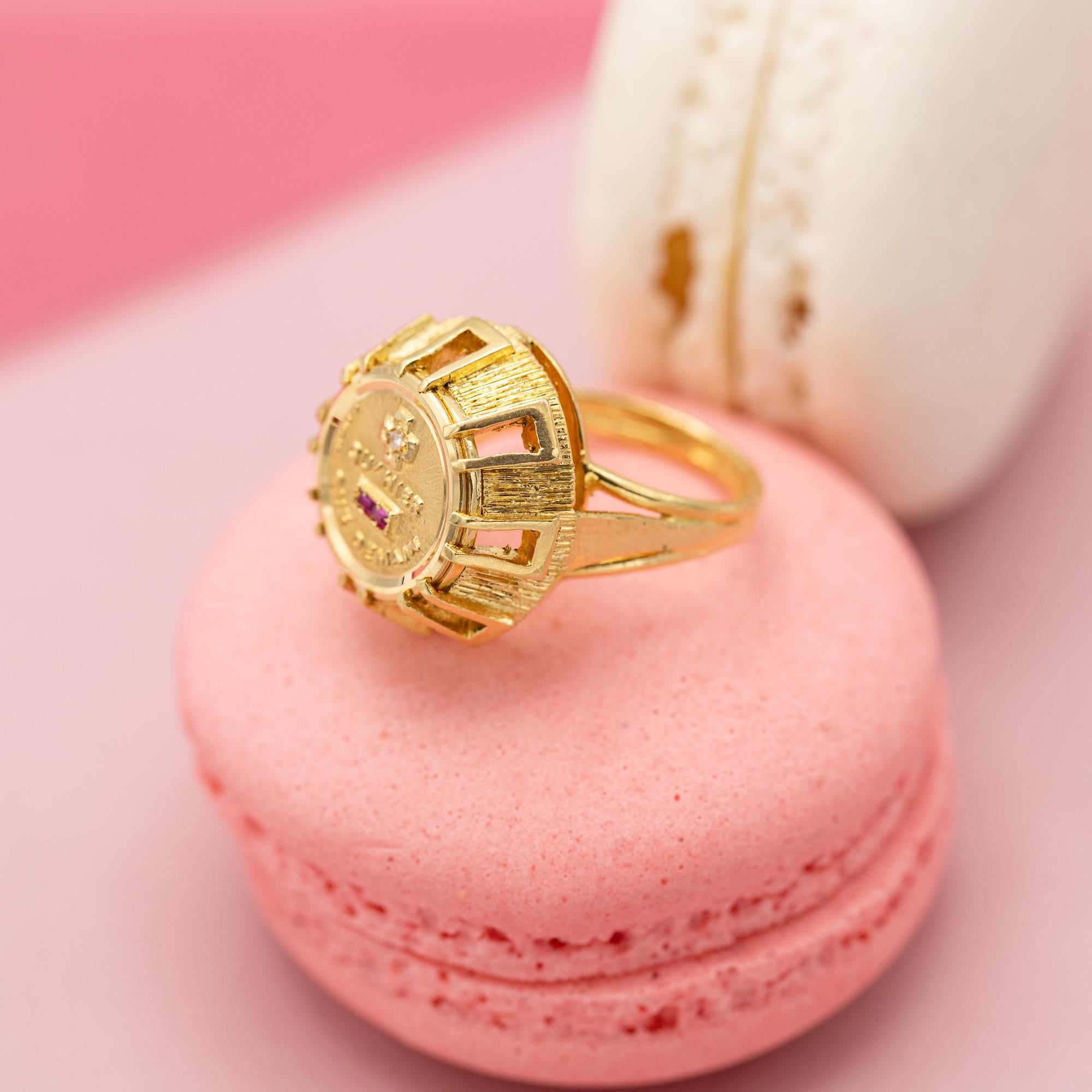 This lovely 18 k Yellow gold ring holds the most beautiful and popular love medallion of all times. This lovely medallion depicts a small cross and minus. Inside the plus we find a small but pretty and sparkly rose cut diamond. The minus is set with