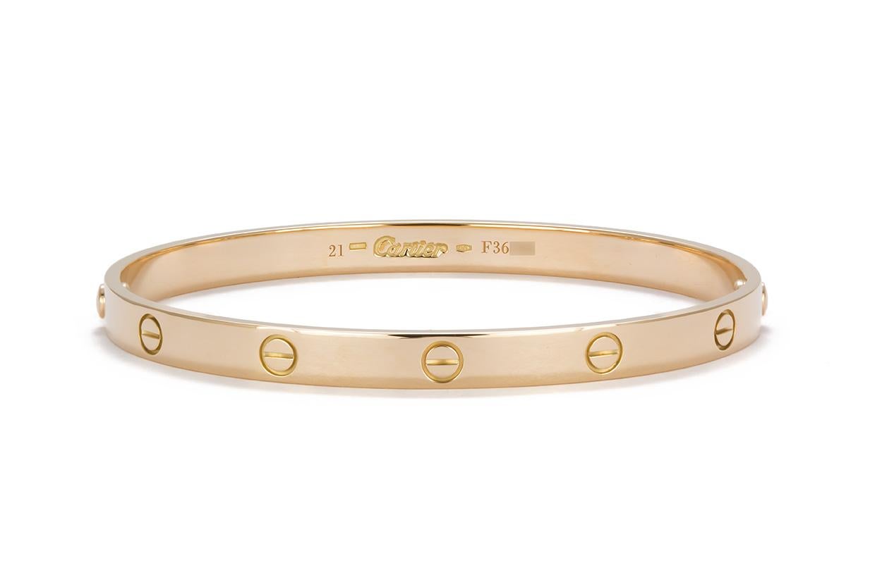 We are pleased to offer this Authentic Cartier 18K Yellow Gold Love Bangle Bracelet Size-21. This bracelet was just sent to Cartier for a polish, it looks good as new. It features the vintage style screw system and comes complete with the original