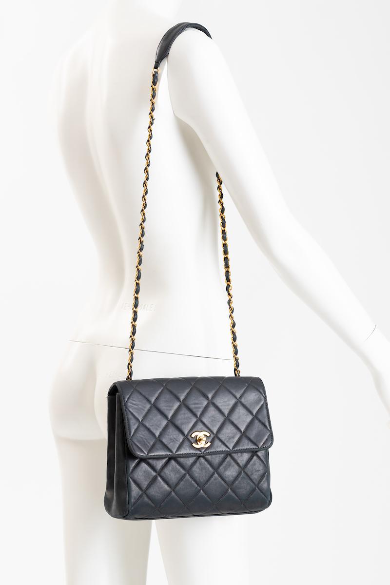 Authentic Chanel classic black quilted lamb skin crossbody purse with long braided leather and gold tone chain shoulder strap, easy for use day and night. 
Features Chanel gold tone signature closure at center front.
The purse has a long open pocket