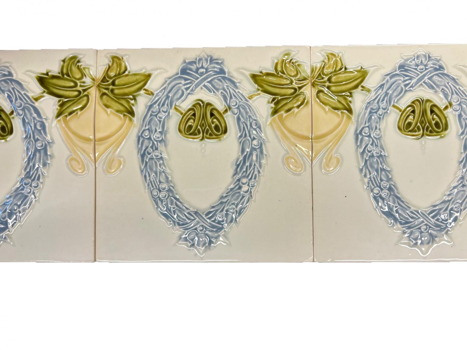 Il s'agit d'un ensemble étonnant de carreaux anciens Art Nouveau faits à la main avec une image d'une couronne de laurier en relief dans un bleu, un vert et un jaune doux. Ces carreaux seraient charmants exposés sur des chevalets, encadrés ou