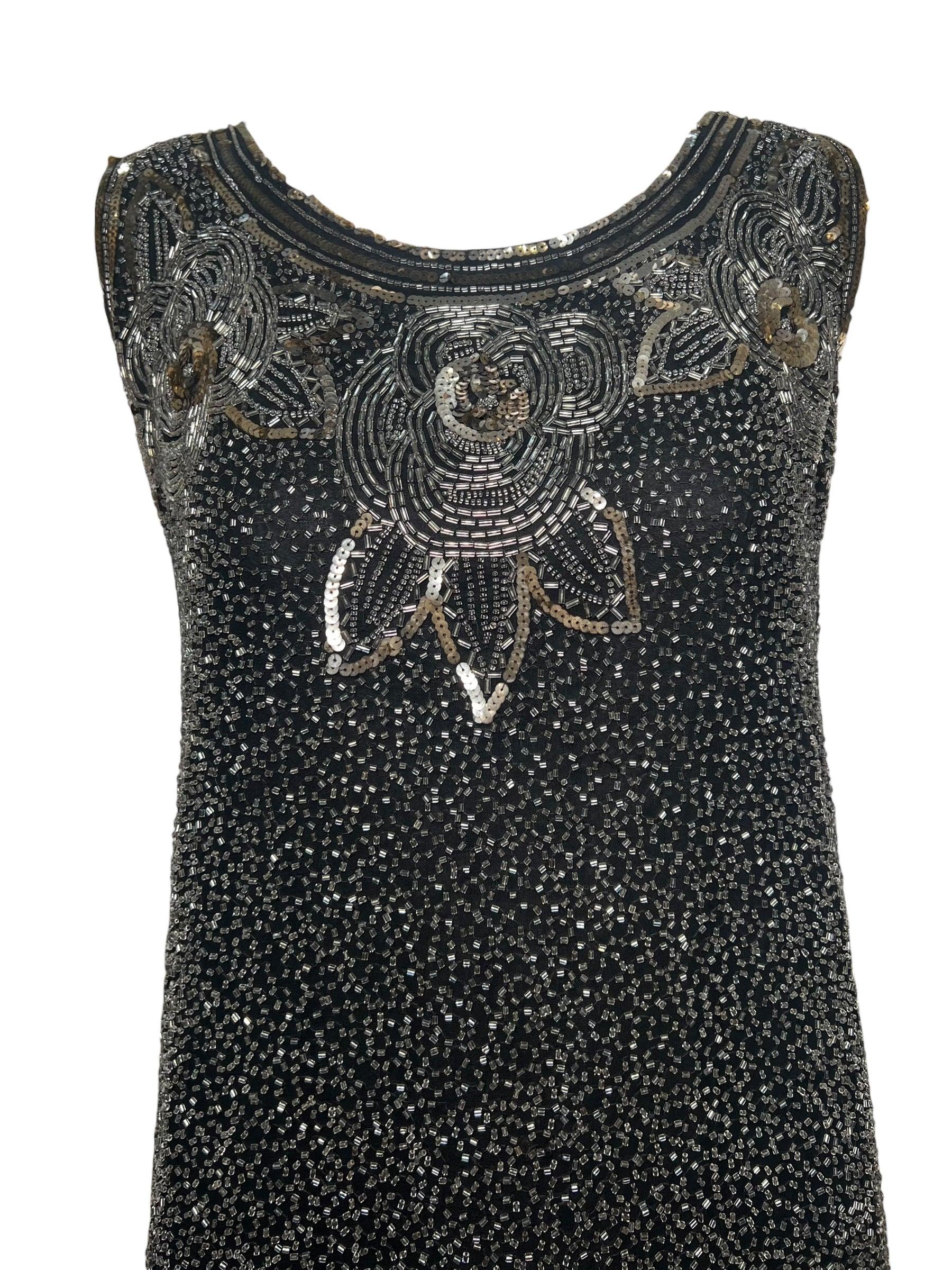 1920's beaded and sequined shift dress on cotton.  The 20s dresses on cotton tend to last a very long time.  Classic tubular silhouette and tapered hem. Geometric deco embellished motif across the bodice and hem. Loose drop waist silhouette. Fully