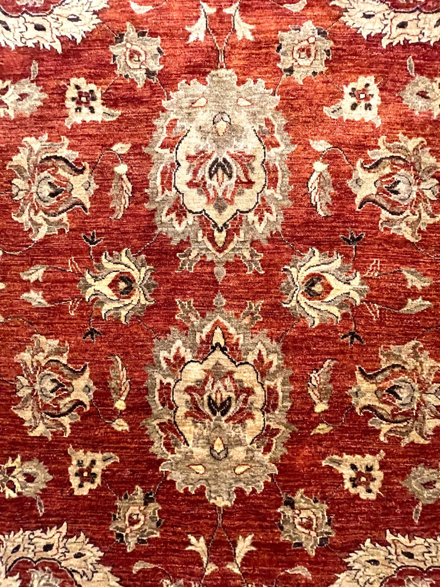 This floral all-over rug is made in Pakistan, it has wool pile and cotton foundation. The base color is rust with brown border. The design is all over semi floral pattern. This rug is a display sample with an excellent condition. The size is this