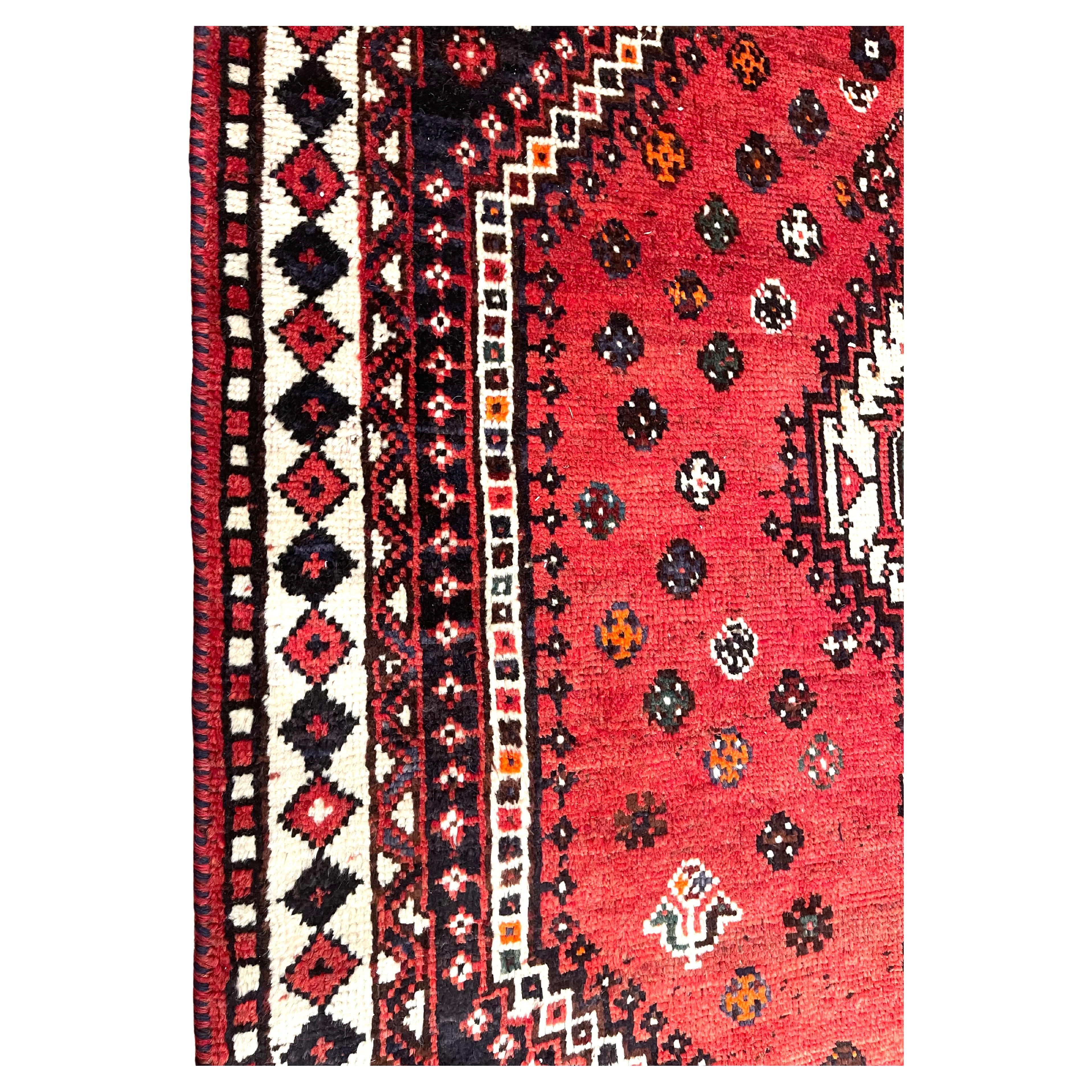 Dieser schöne Teppich ist ein authentisches Stück aus Shiraz, Iran, einer Region, die für ihre reiche Tradition handgewebter Teppiche bekannt ist. Ganz aus Wolle gefertigt, zeigen sowohl der Flor als auch der Unterbau die Strapazierfähigkeit und den