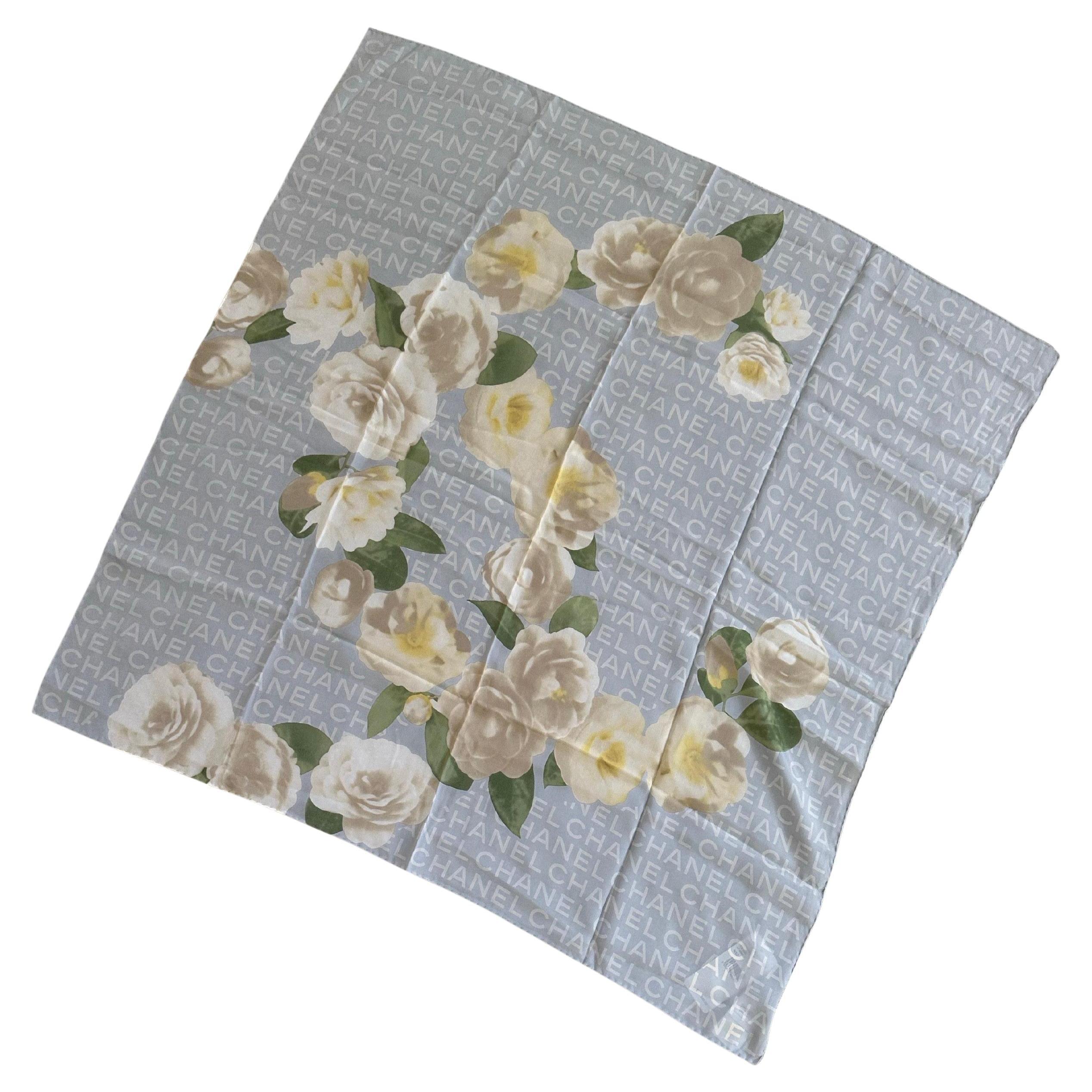 Elegant foulard italien vintage en soie roulée à la main par Chanel, circa 1980. Le foulard n'a jamais été utilisé, il est en excellent état et présente un magnifique imprimé floral de camélia. Il conserve ses étiquettes Chanel et Neiman Marcus