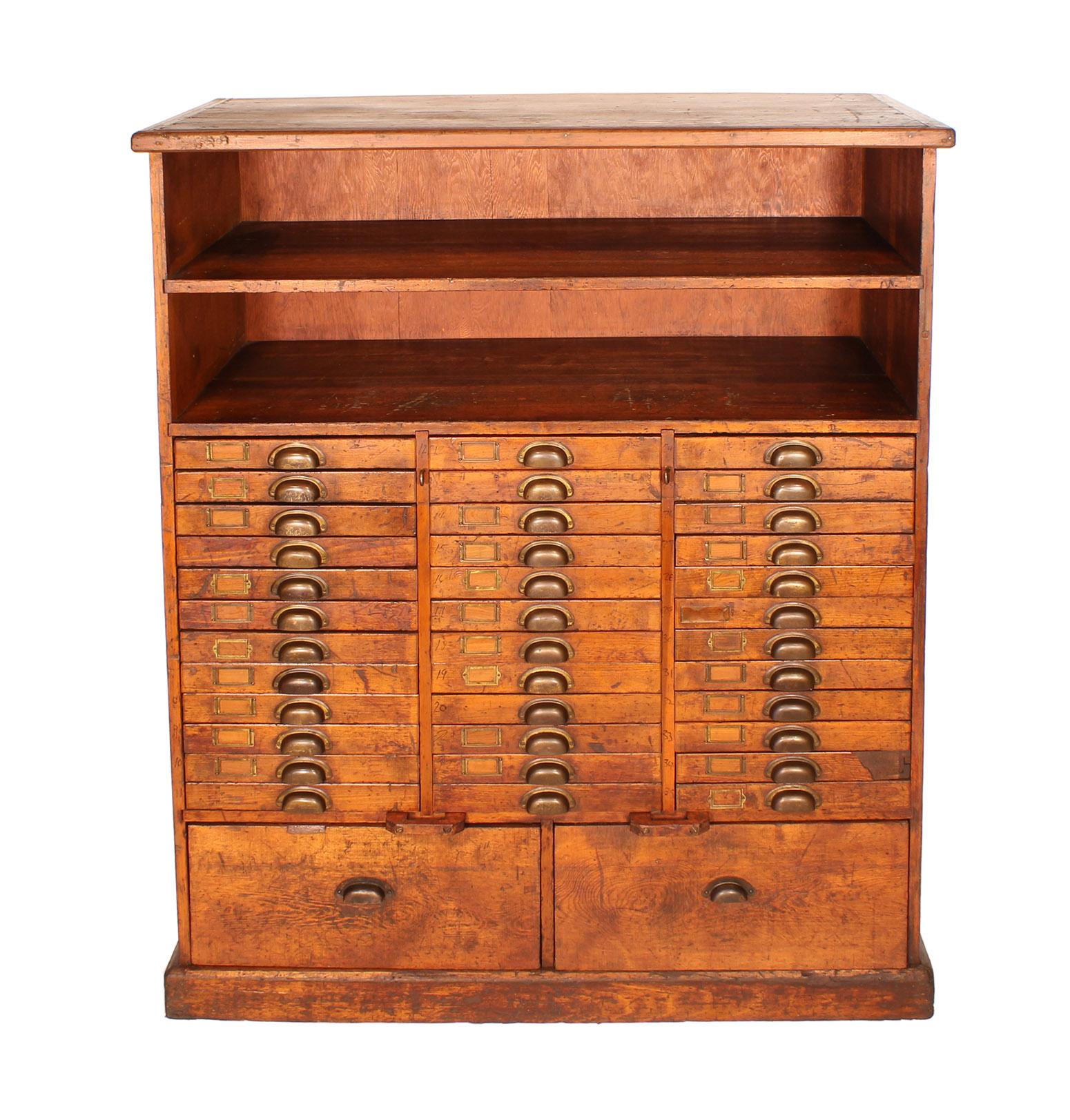 Vintage industrial authentic 1920s machinists tools and parts storage cabinet. Features thirty six smaller drawers, two larger drawers and two cubby compartments. Brass hardware, handles and name plates are used throughout, with some of the drawers