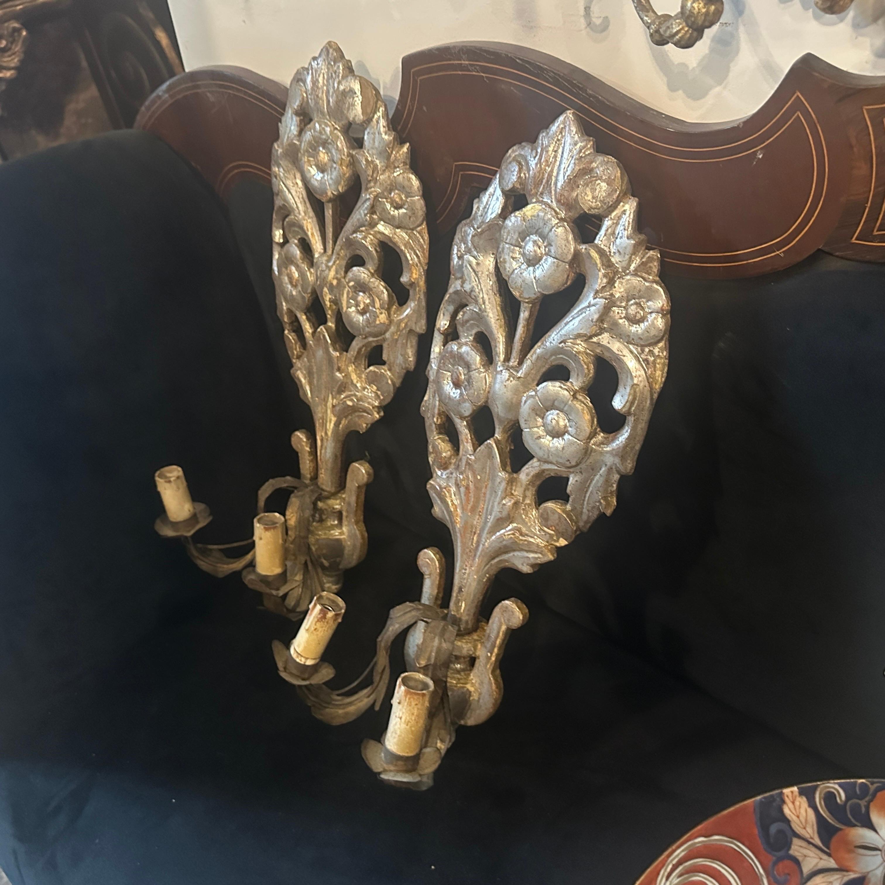 Esta excepcional pareja auténtica de apliques de pared de época Luis XVI es un raro ejemplo de las artes decorativas sicilianas de finales del siglo XVIII. Talladas a mano en madera de tilo y originalmente plateadas (doradas con pan de plata), estas