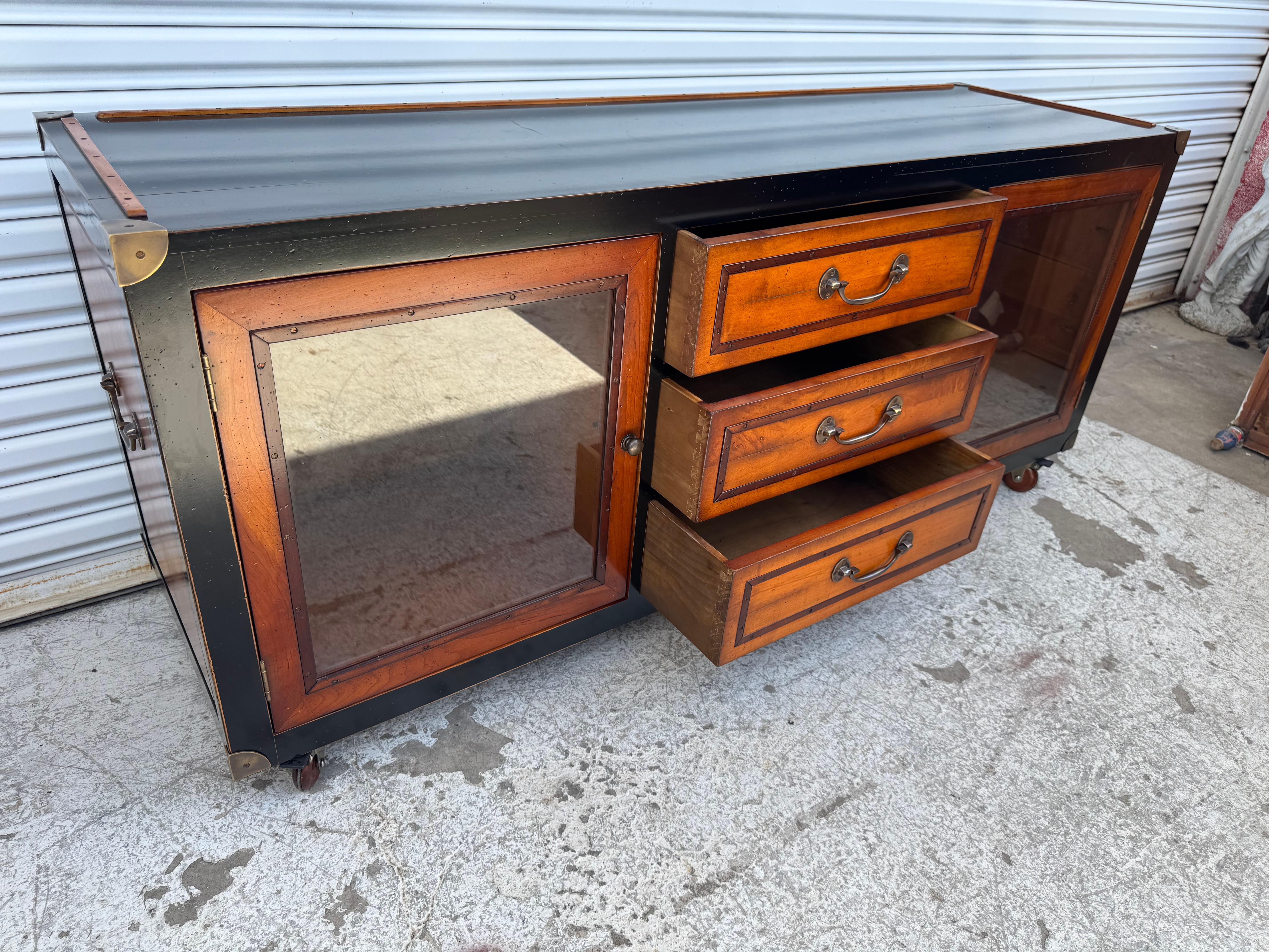This entertainment center has 3 middle drawers for lower storage and utility items.  It has 2 doors which open up to reveal lots of storage space.
The sides have bail pulls and the back is also refinished.
The piece has brass accents.

THERE IS ALSO