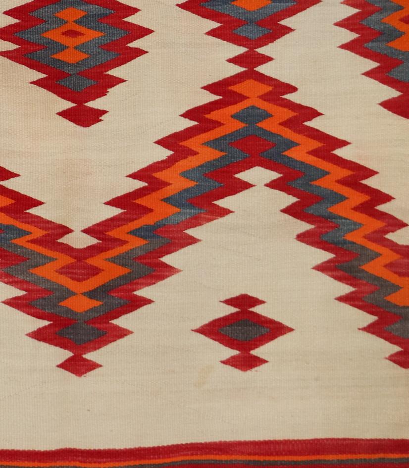 This stunning Navajo (Diné) rug from the Transitional Period (circa 1875–1910) features a bold serrated diamond pattern—an iconic and highly collectible design in Navajo weaving traditions. Handwoven by Diné artisans using native handspun wool, this