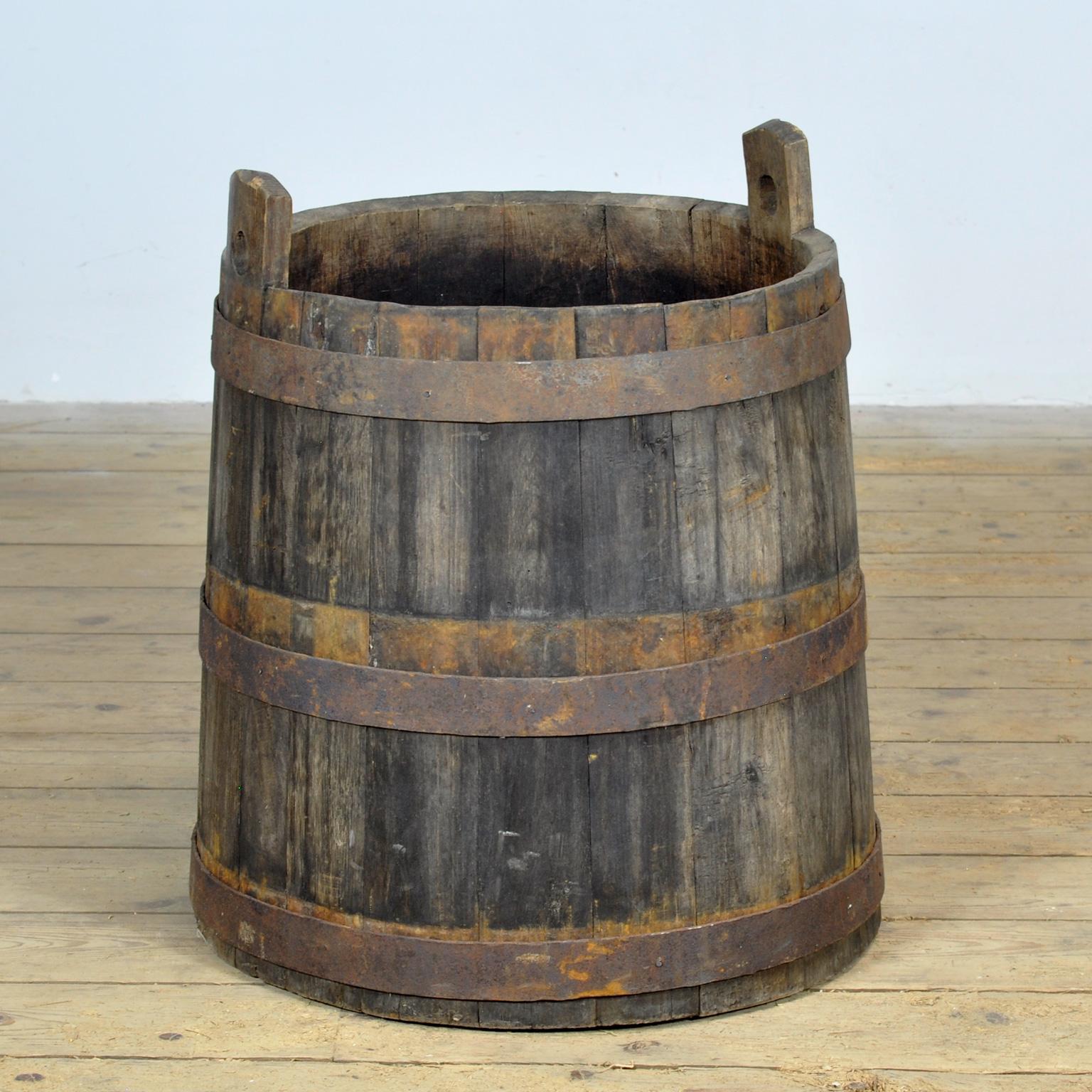 Authentic oak storage barrel with a robust and rustic appearance. This sturdy barrel is made of solid oak wood and reinforced with iron bands for extra durability. The natural aging of the wood gives it a characterful, vintage look. Perfect to use