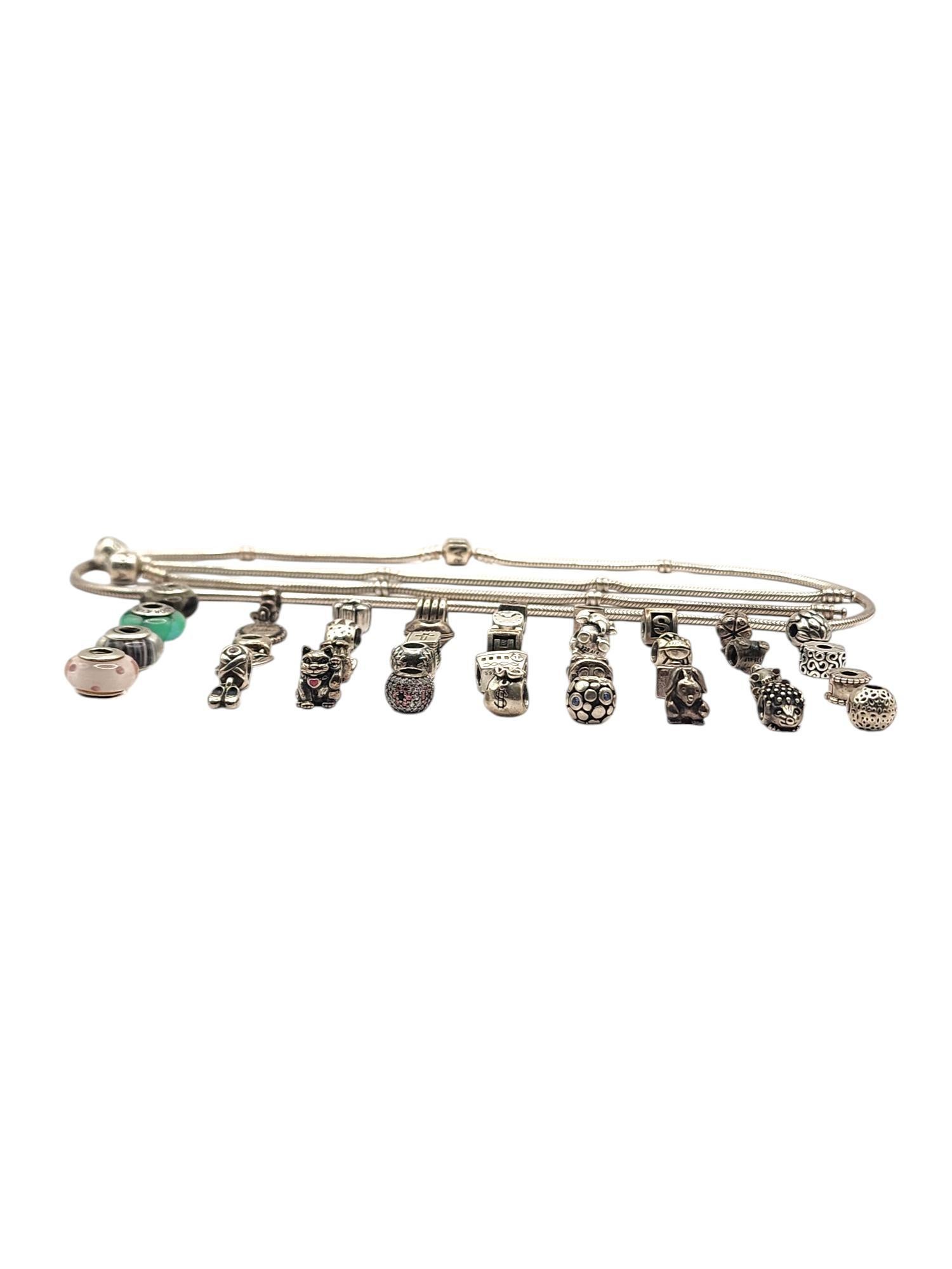 Authentic Pandora Lot of 40 Sterling Silver Charms, Bracelets & Necklace

Lot features 37 sterling silver authentic Pandora charms, including dangle charms, cz charms, murano beads, clips and more!
2 Pandora snake chain bracelets
7.75