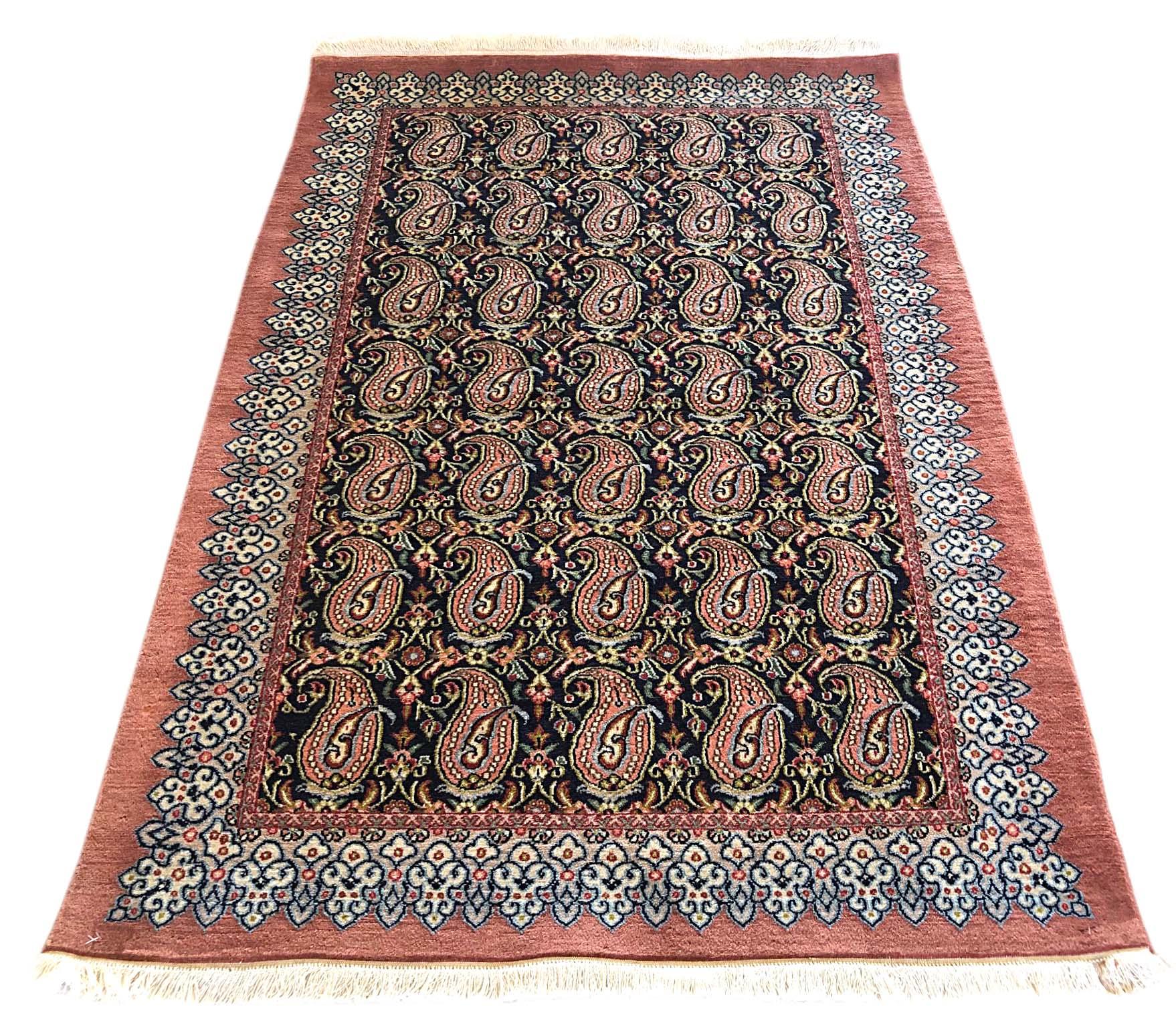 This authentic Persian Qum rug has wool pile and cotton foundation, this beautiful Persian Qum has paisley design with floral pattern. Qum rugs are well known for their high quality and unique design. The base is dark blue and border color is