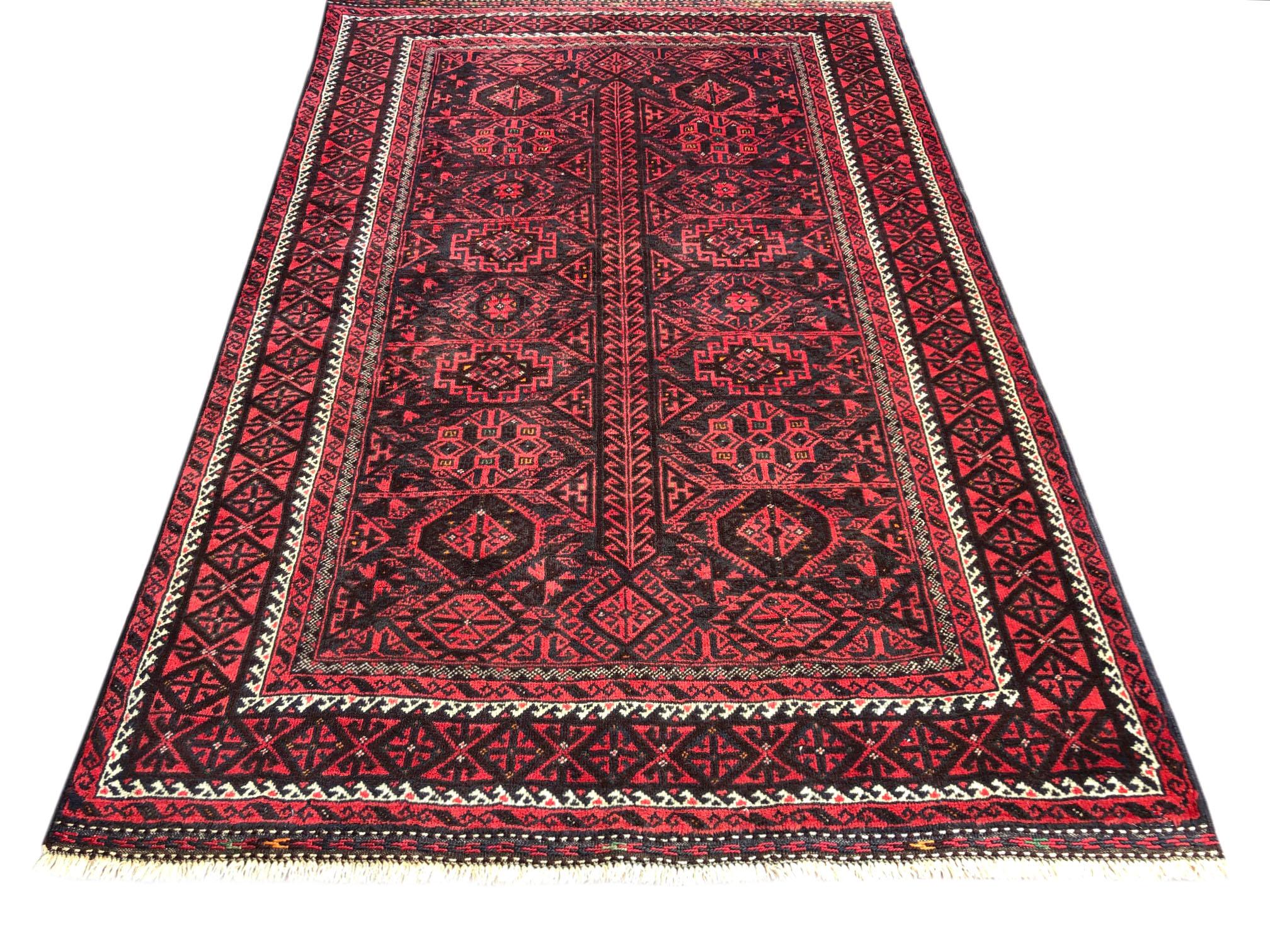 This authentic Persian Baluchi rug has wool pile foundation which is hand knotted by the nomads of Baluchi. The age of this rug is almost 50 years old. The size of this rug is 4 feet 5 inches wide by 6 feet 3 inches tall. Baluchi rugs are soft and