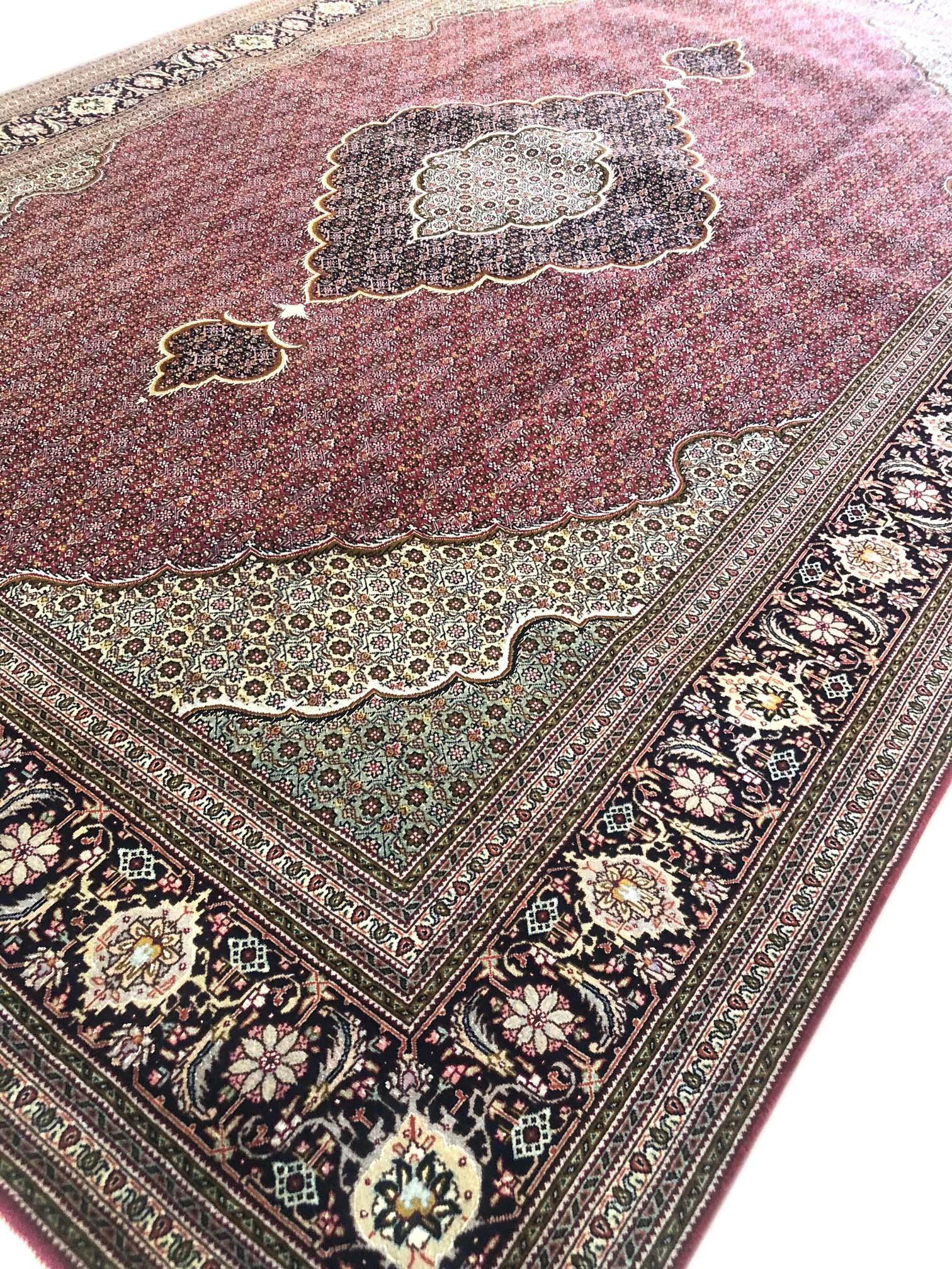 Tabriz rugs are well known for their excellent weaving and design. One of the very famous patterns of Tabriz rugs are Fish Design known is Mahi. This beautiful piece has wool and silk pile with cotton foundation. The base color is burgundy and the