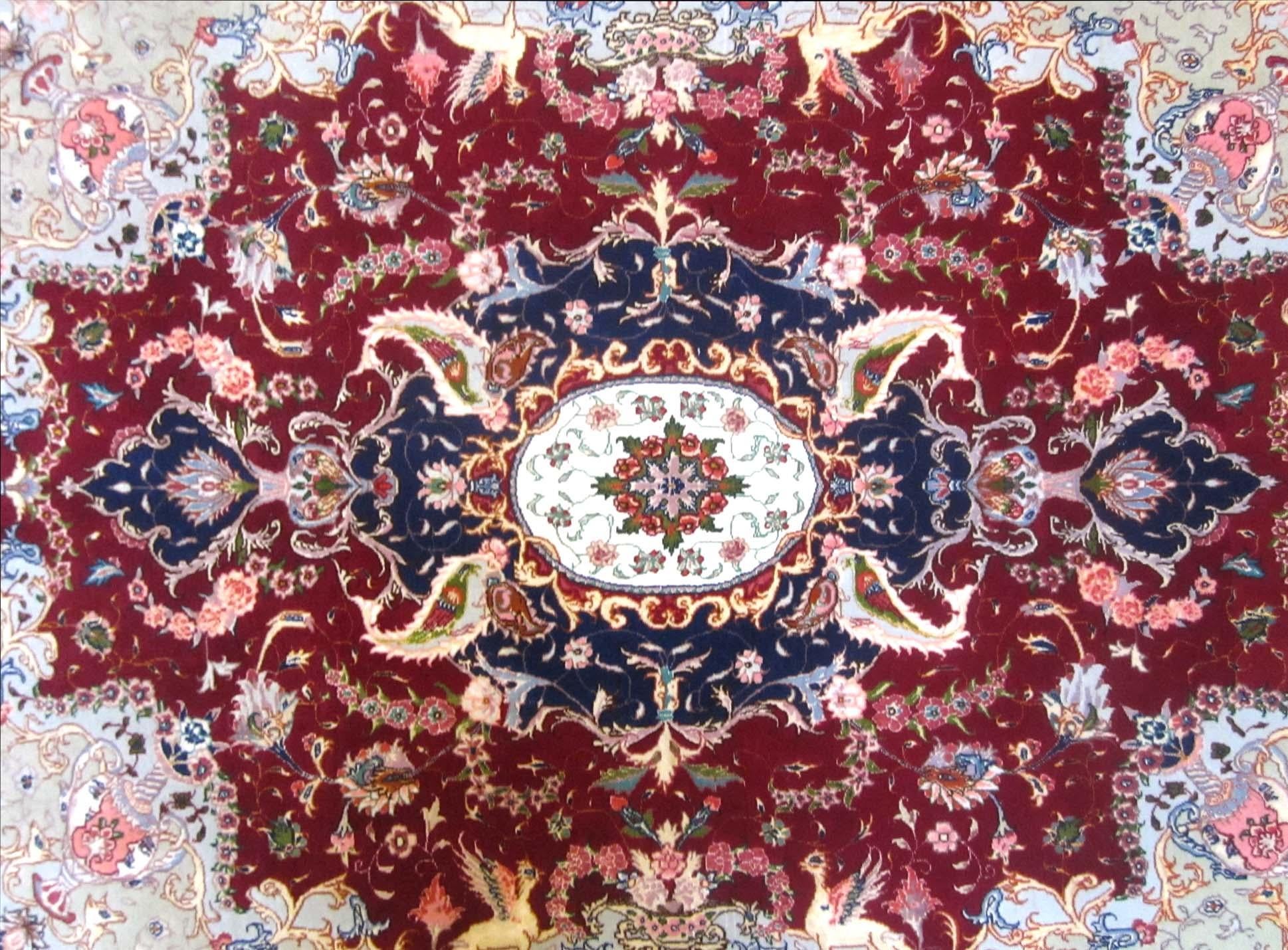 This Persian Tabriz rug has wool and silk pile and cotton foundation. This high-end rug features a unique floral rug pattern that has red base color with dark blue border. The size is 5 feet wide and 6 feet 7 inch long. This piece is brand new with