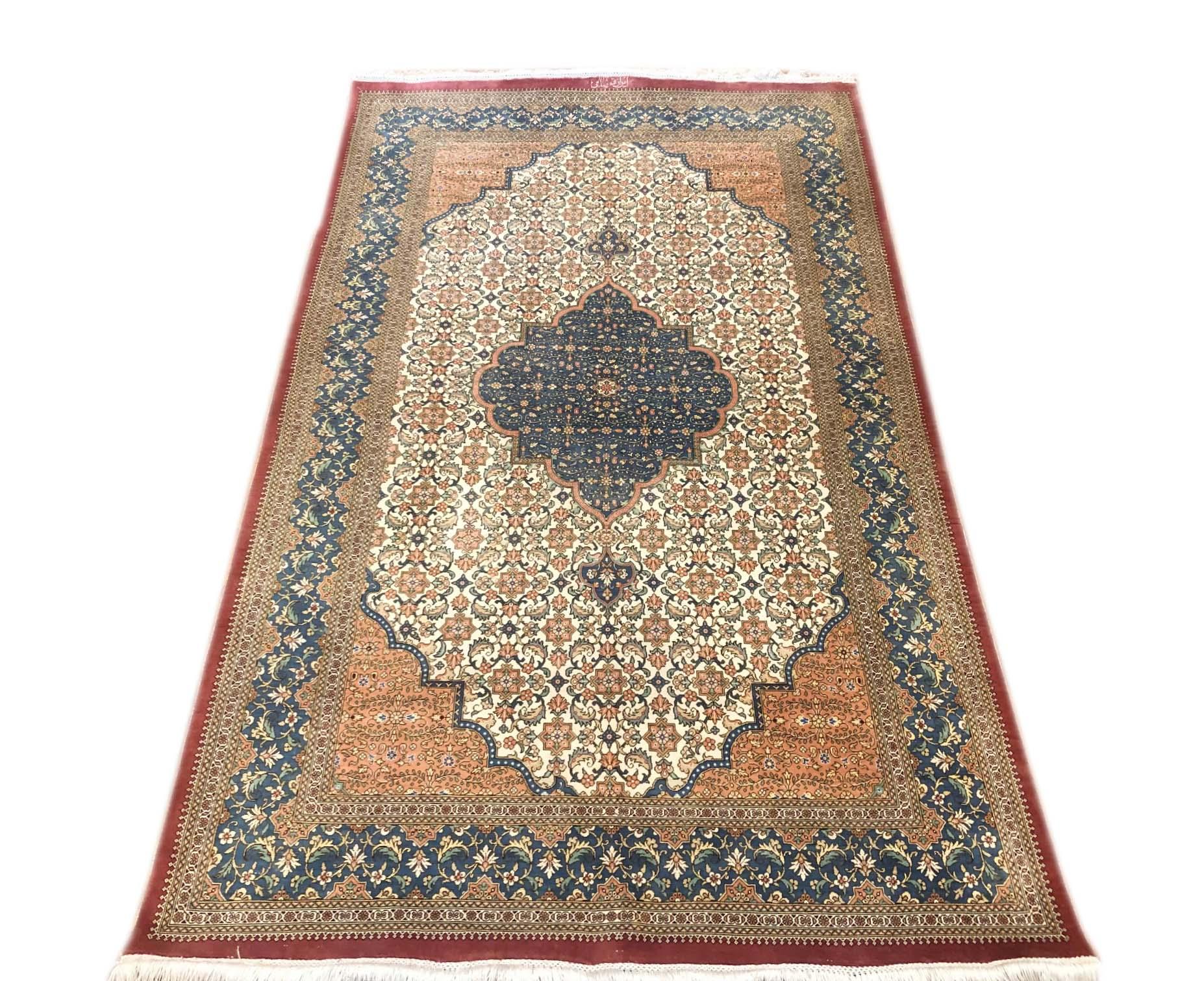 This authentic Persian Qum rug has silk pile and silk foundation in excellent condition. The color combination in this rug is absolutely outstanding. The base color is cream and the border is blue. The design in this piece is medallion floral. The