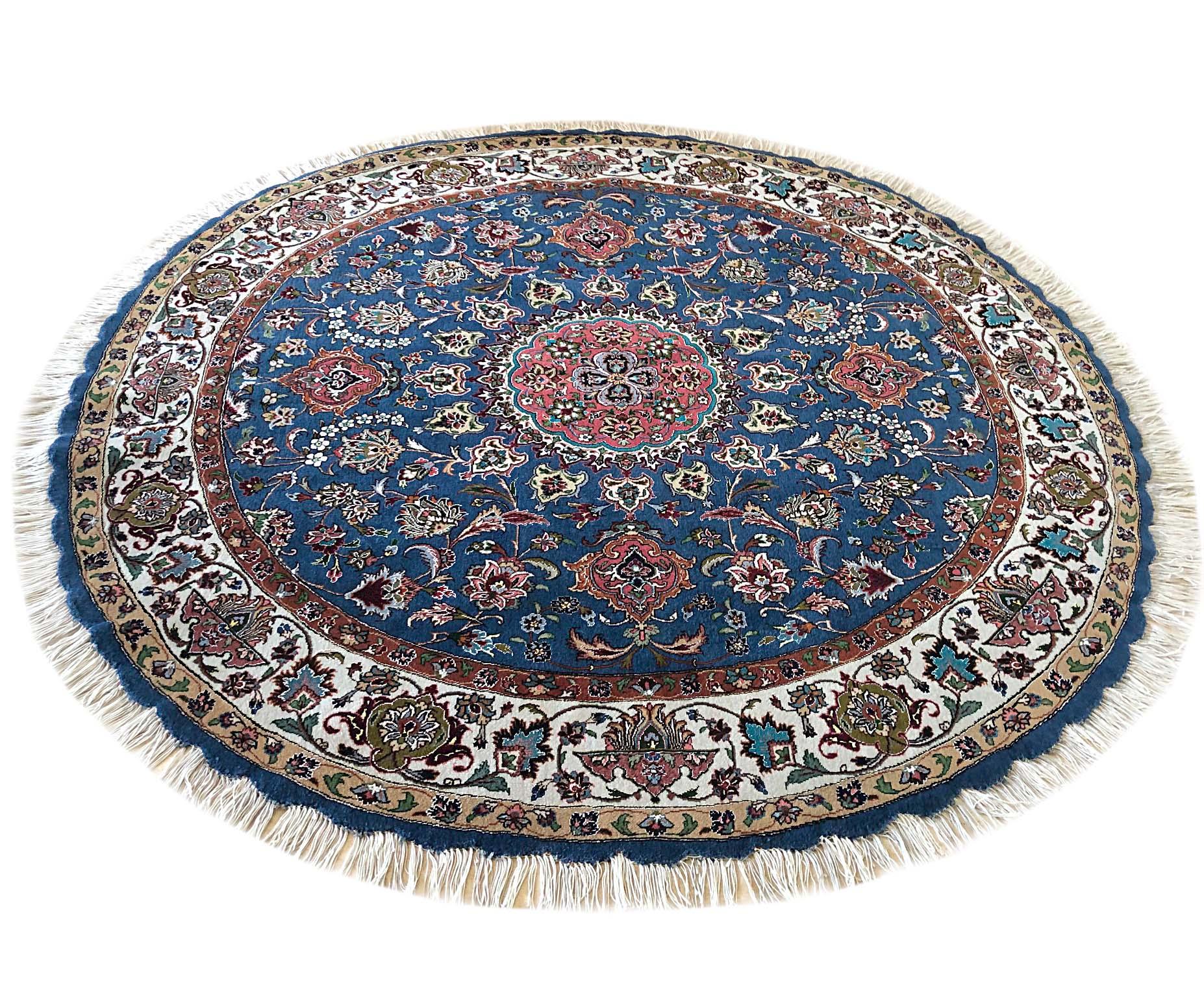 This authentic Persian handmade round rug has wool and silk pile with cotton foundation. This beautiful rug is from Tabriz and the design is medallion, floral. The base color is blue and the border is cream. The size is 5 feet diameter. This is a